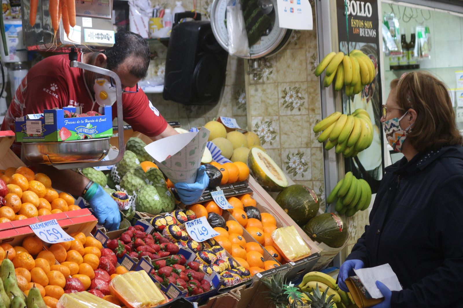 Una clienta compra fruta en uno de los puestos del Mercado de Abastos