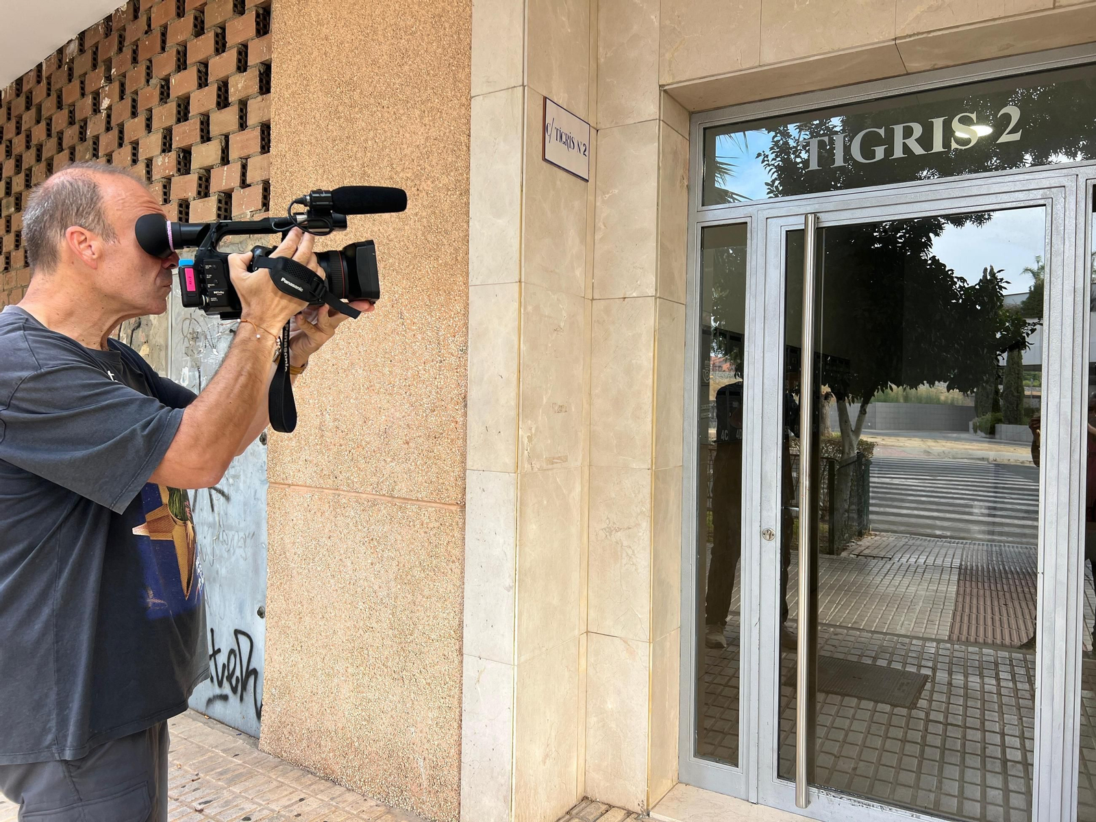 Un cámara de televisión toma imágenes del lugar del crimen.