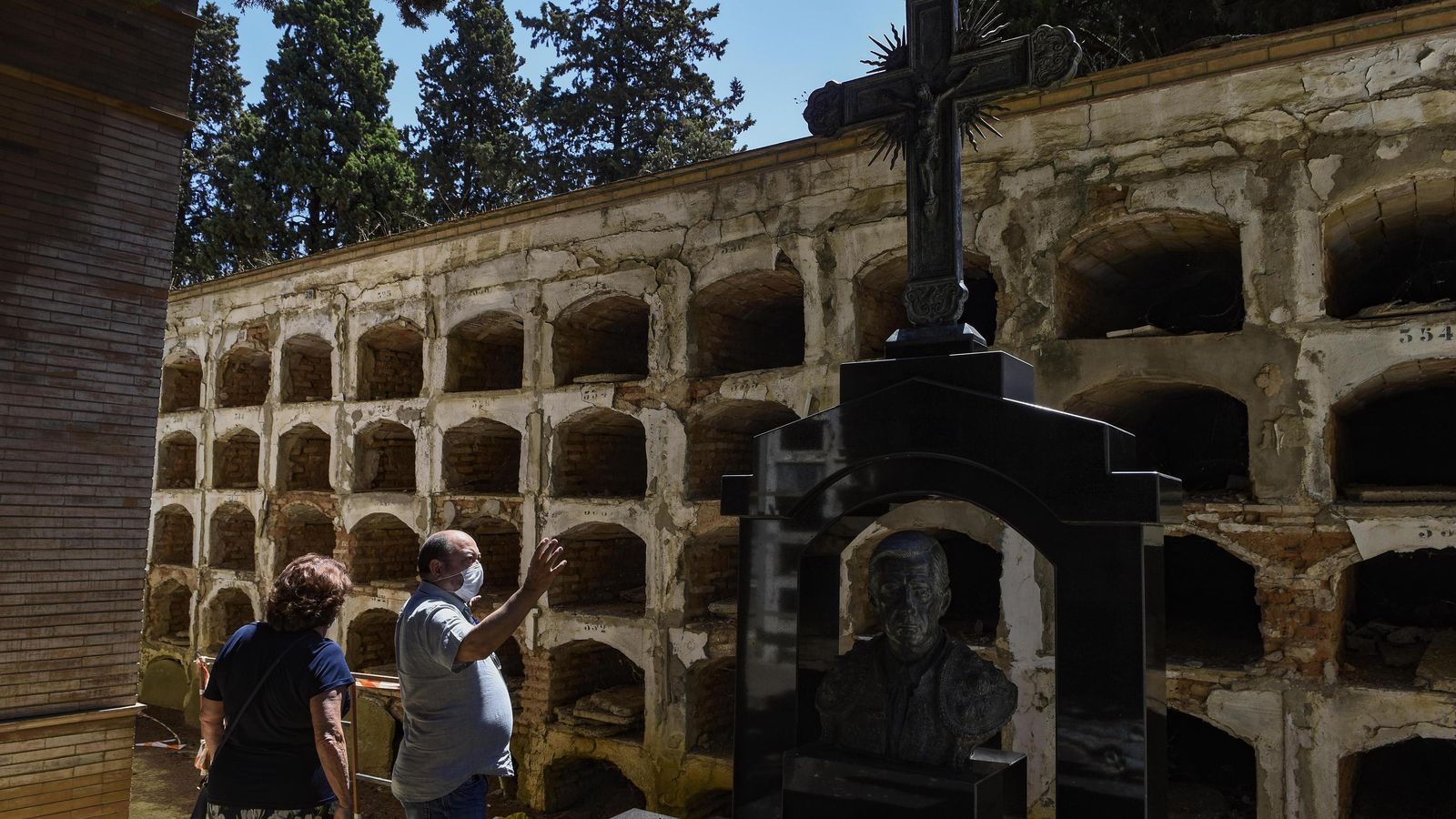 Una pareja mira unos nichos en un estado deplorable en el cementerio de San Fernando.