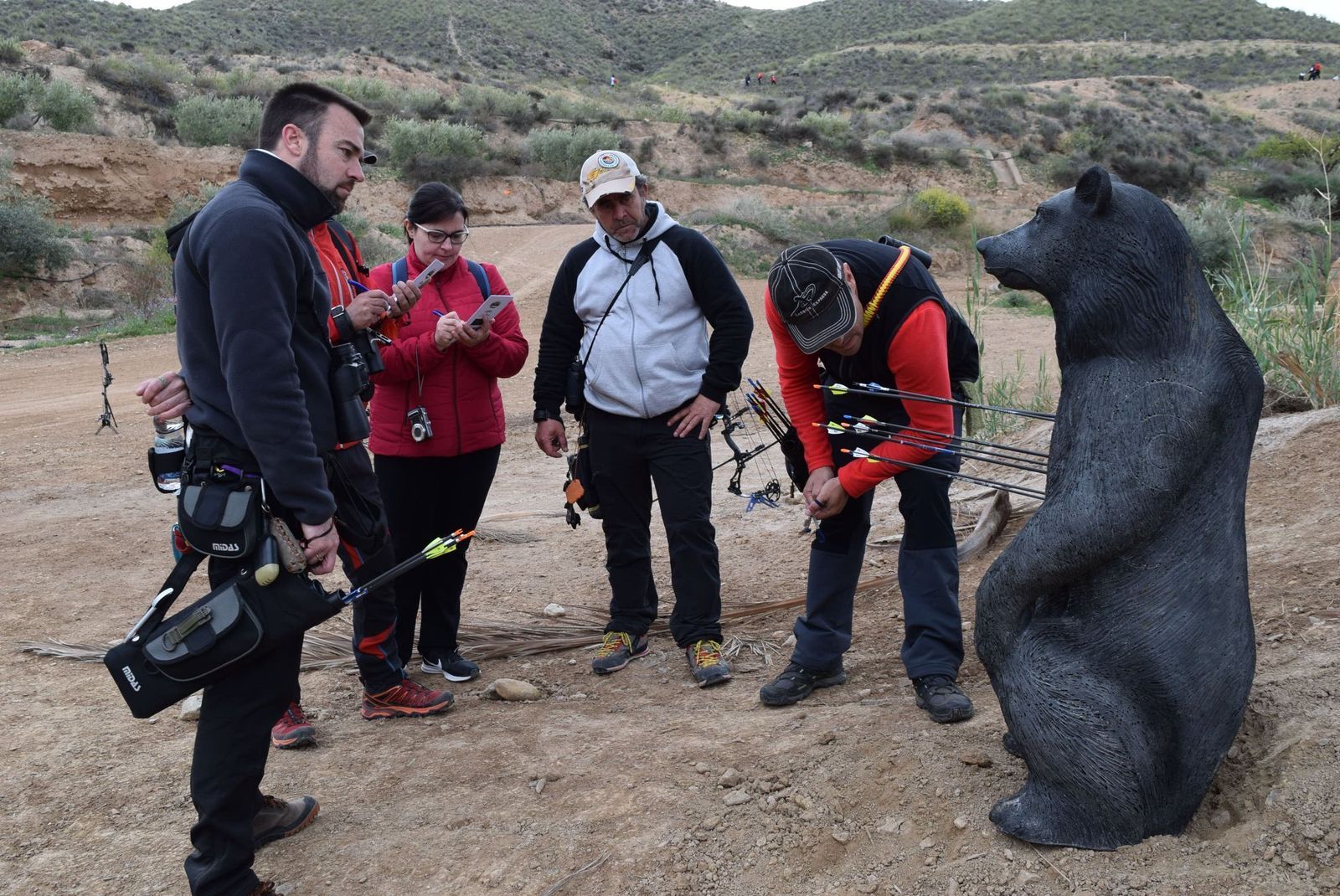 Los arqueros observan el oso tras realizar sus tiros.