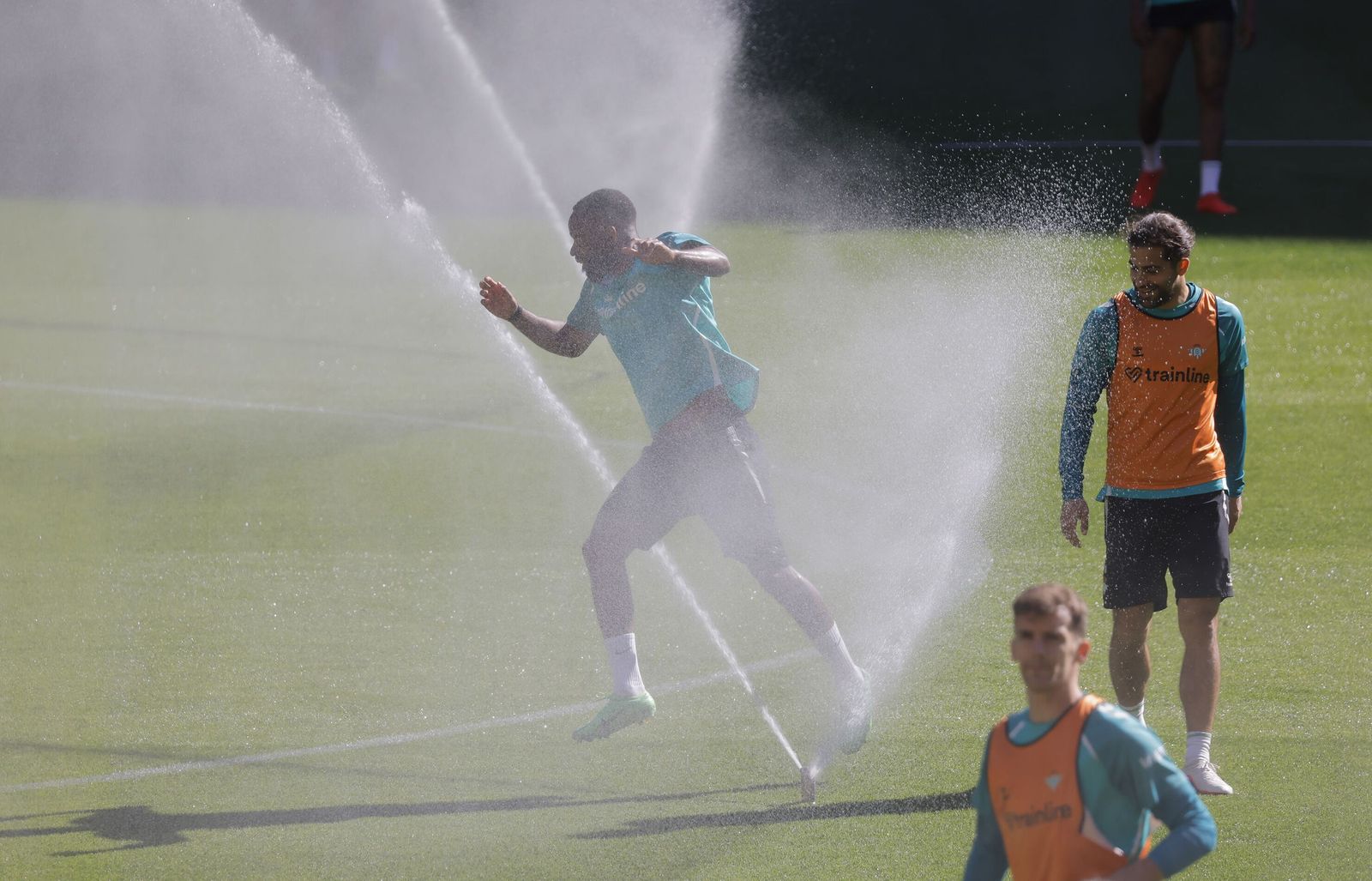 Bakambu se refresca con los aspersores en el entrenamiento en La Cartuja de este sábado.