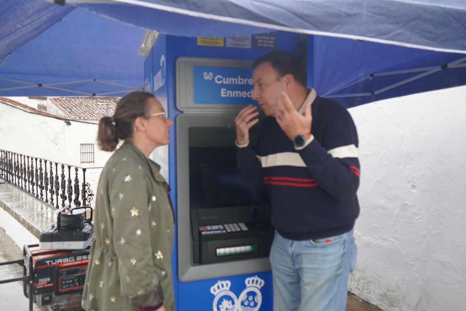 La alcaldesa de Cumbres de Enmedio, María Reyes Paez, y el diputado Juan Carlos Roda conversan ante el nuevo cajero de la localidad. La alcaldesa de Cumbres de Enmedio, María Reyes Paez, y el diputado Juan Carlos Roda conversan ante el nuevo cajero de la localidad.