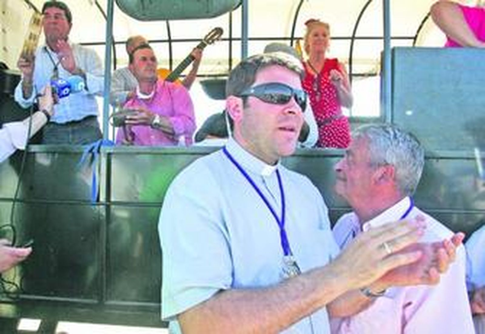 El capellán de la hermandad, junto a una carreta.