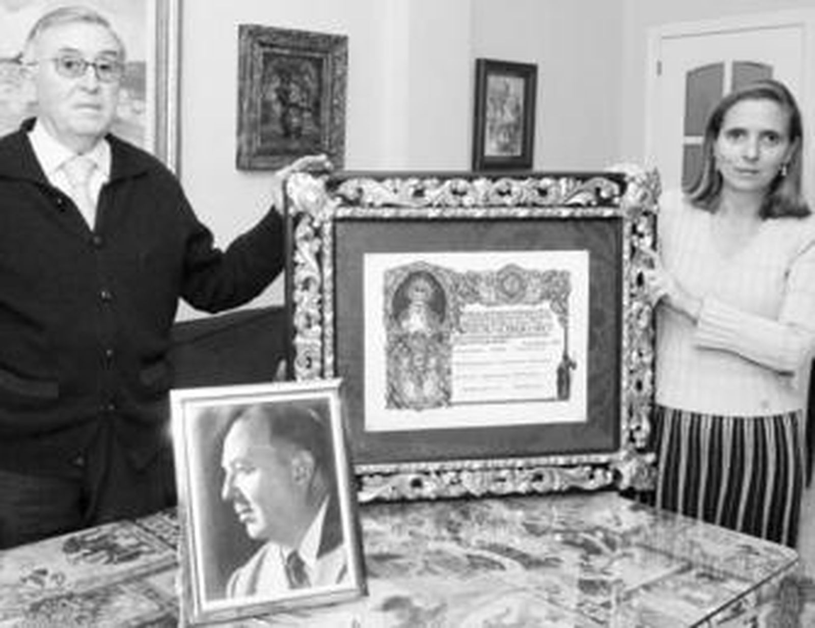 Gonzalo Rodríguez-Buzón y su hija Ángeles, con el pergamino del Pregón de 1956 y el retrato del orador.