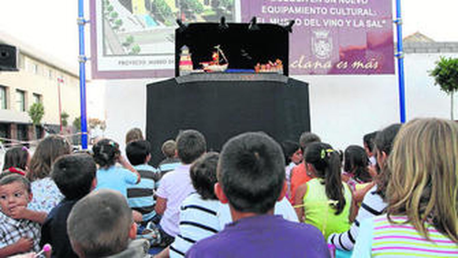Los pequeños contemplan una de las obras de títeres en la Plaza de las Bodegas.