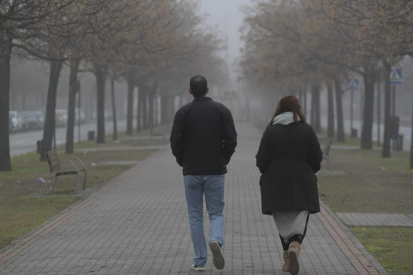 Dos personas caminan por la Avenida Luís Miranda Dávalos contemplando la niebla Dos personas caminan por la Avenida Luís Miranda Dávalos contemplando la niebla