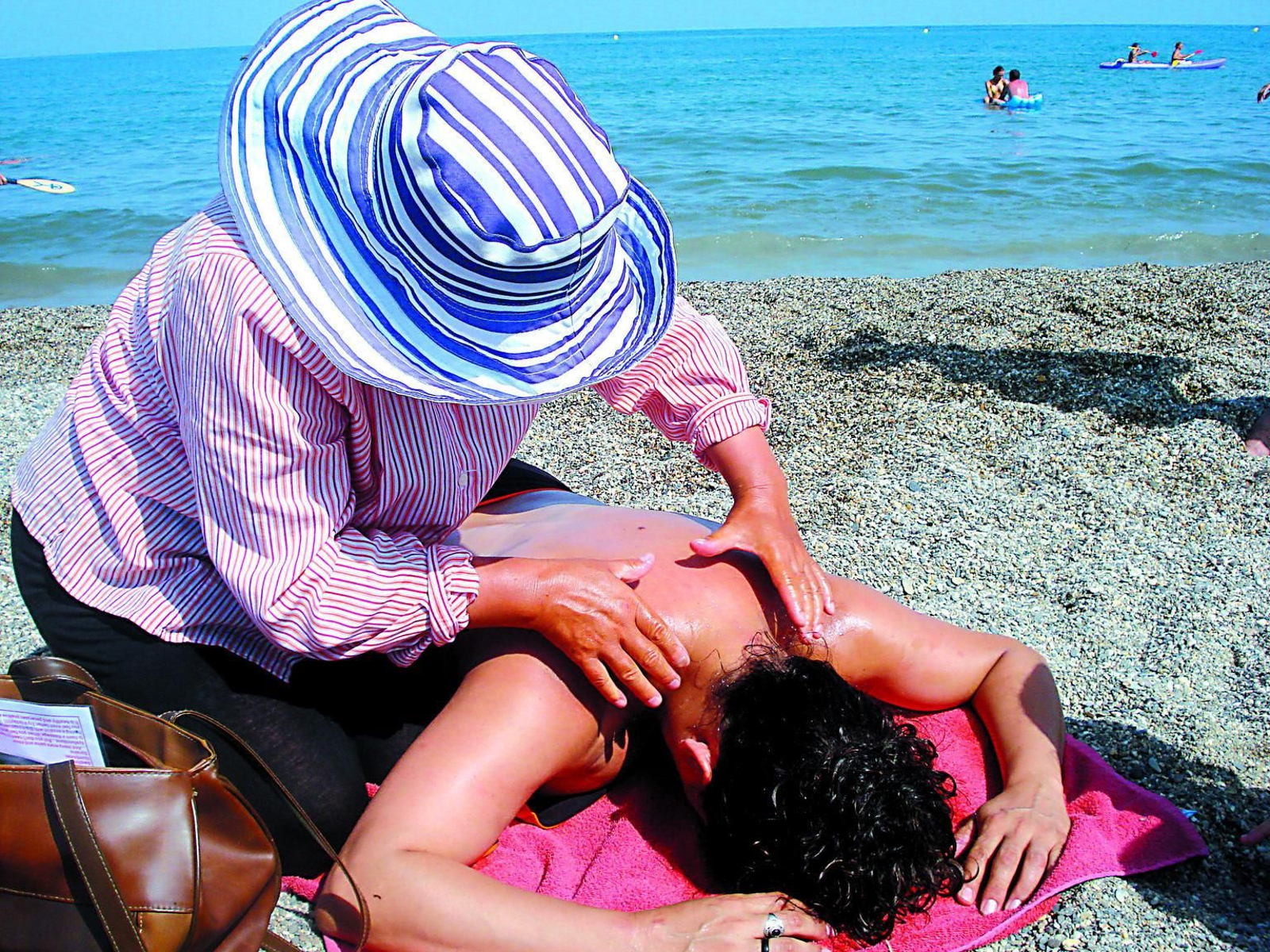 Una persona da un masaje en una playa de Málaga.