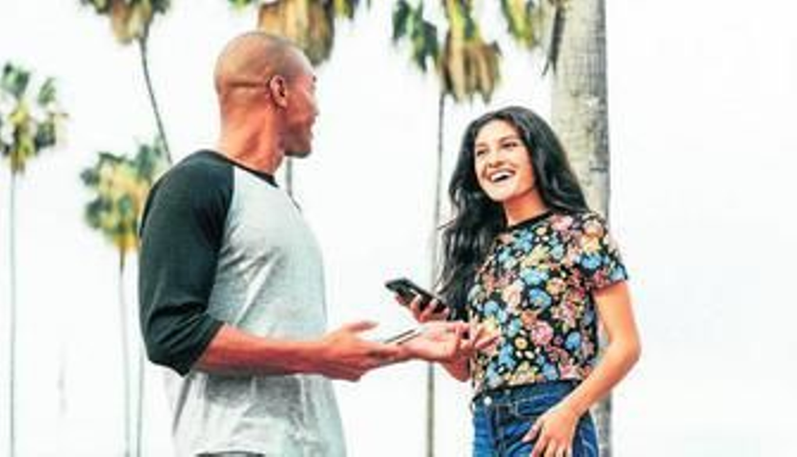 Dos jóvenes usan sus teléfonos móviles para conocerse mejor.