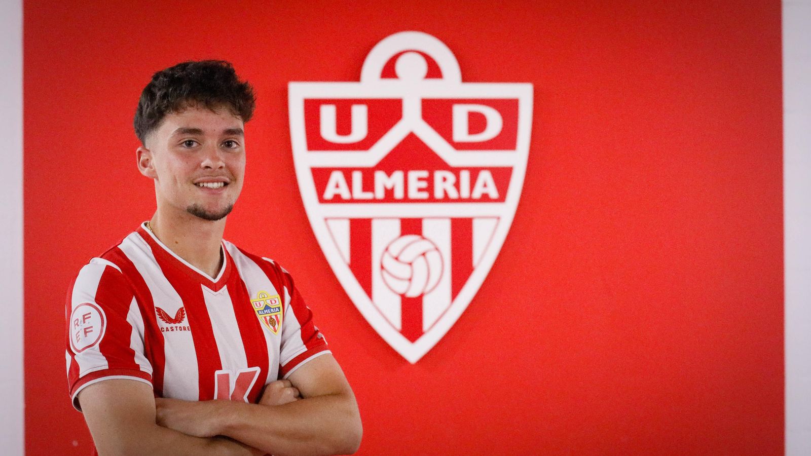 Juanjo Linares posa junto al escudo de la UD Almería en las dependencias del Power Horse Stadium.