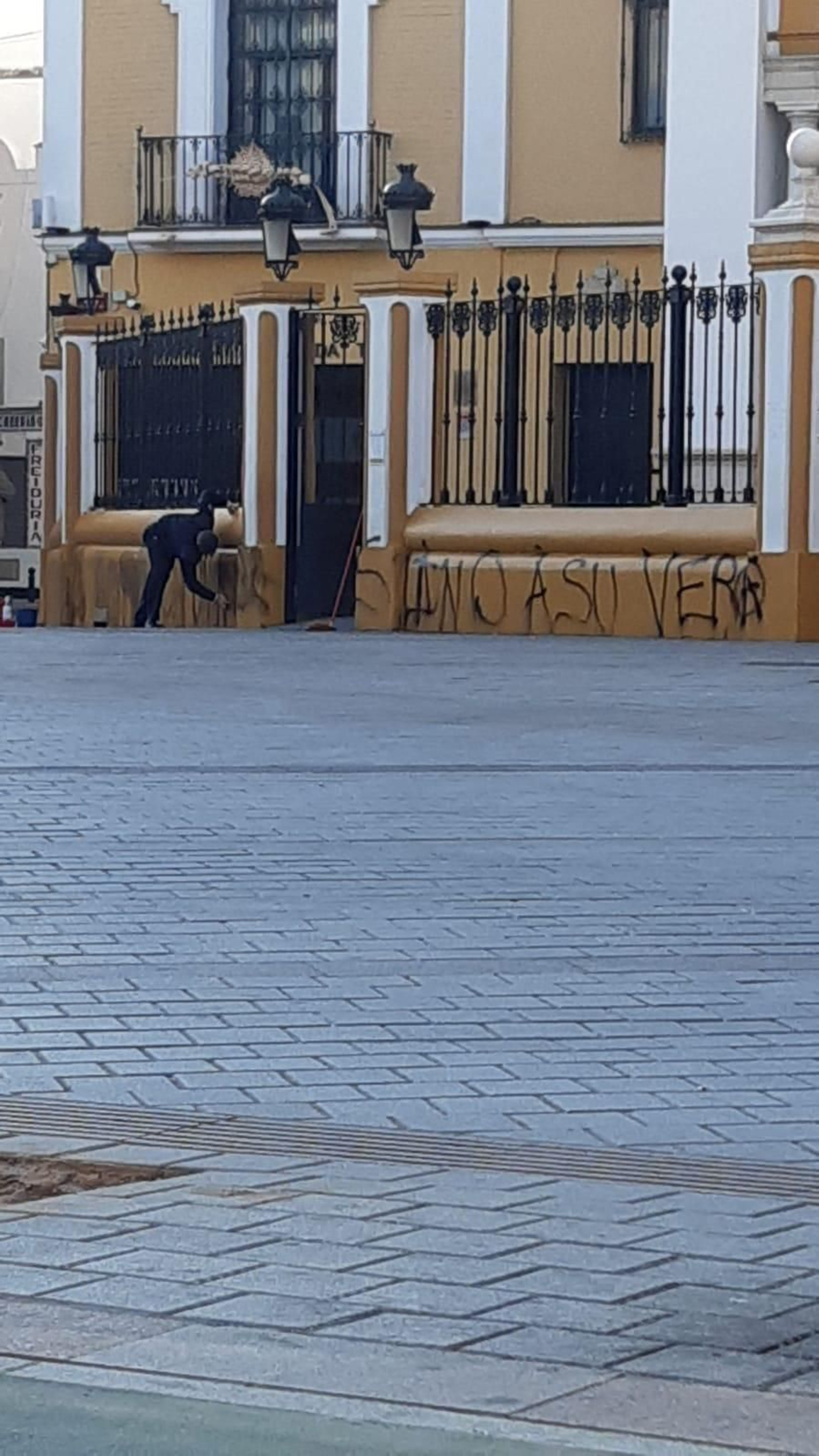 Un trabajador de la hermandad borrando la pintada.