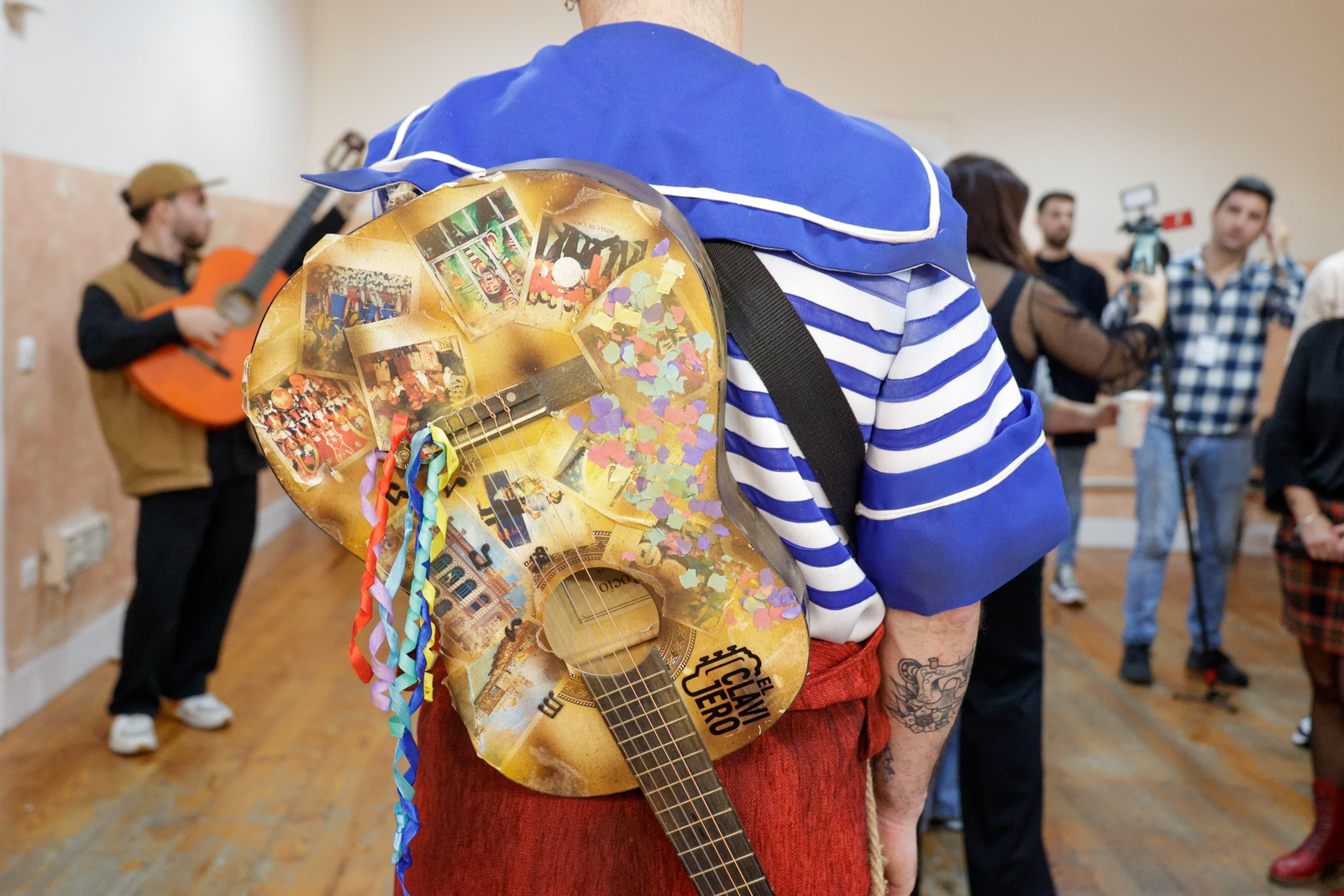 Las guitarras de los comparsistas de 'Y seguimos cantando', con papelillos y fotos de agrupaciones míticas.