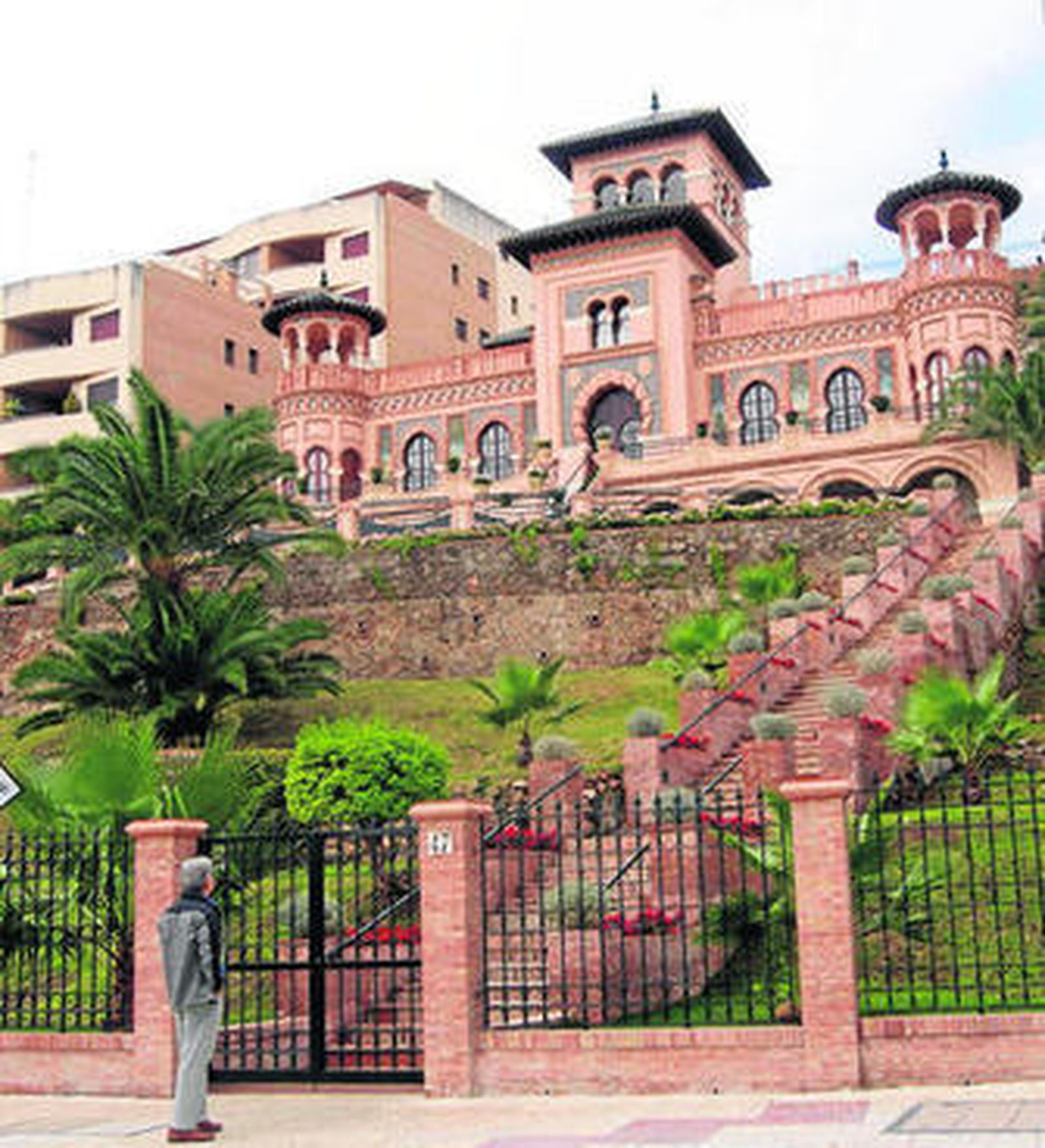 Un hombre mira la fachada del palacete.