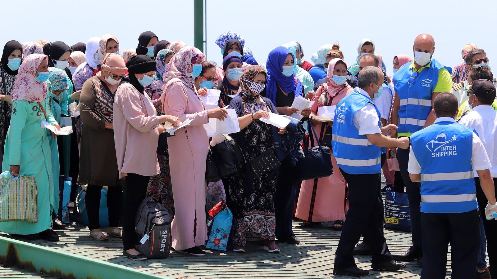 Las trabajadoras agrícolas muestran la documentación para poder regresar a su país de origen.