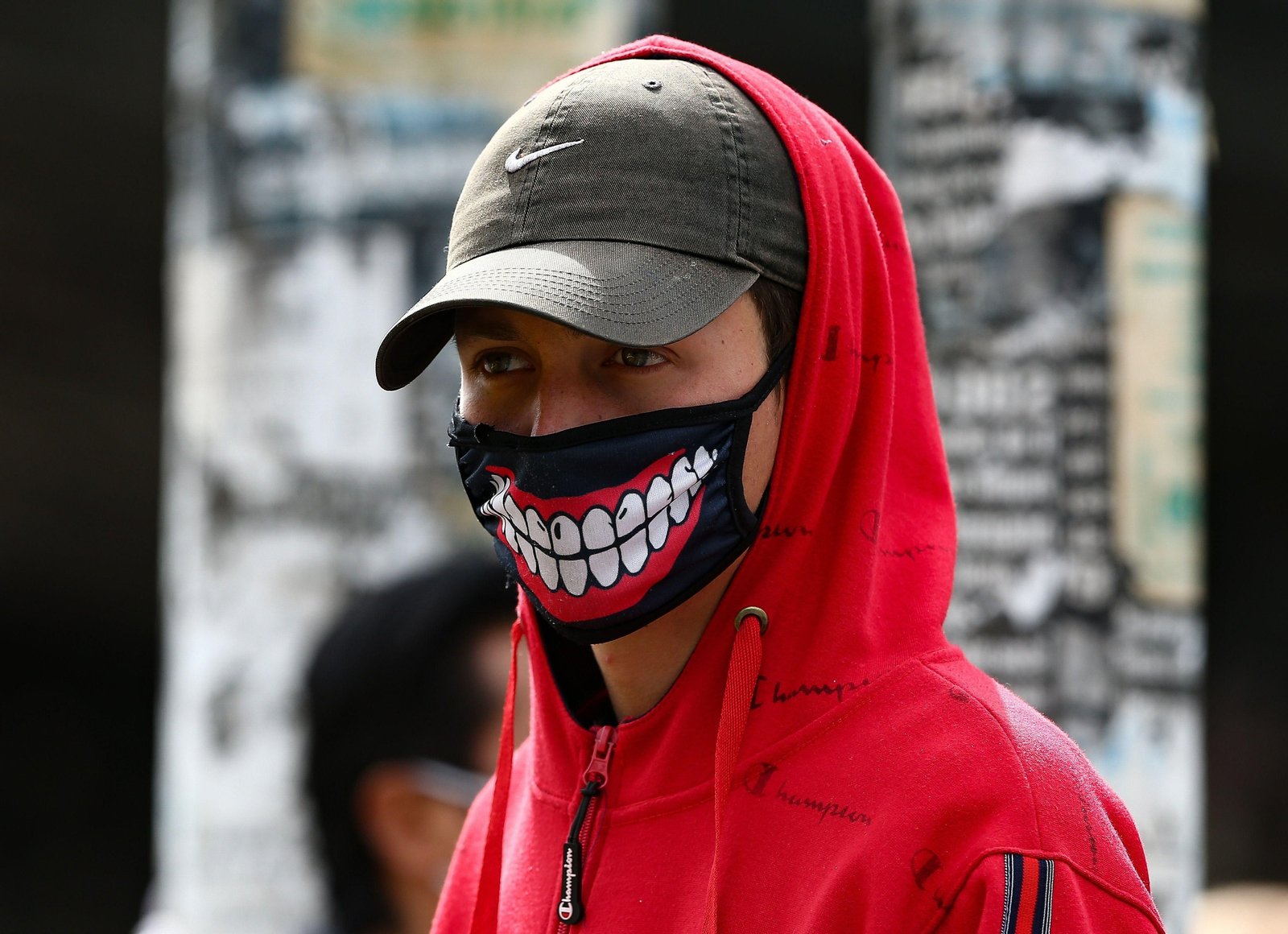 Un joven camina por la calle con una mascarilla