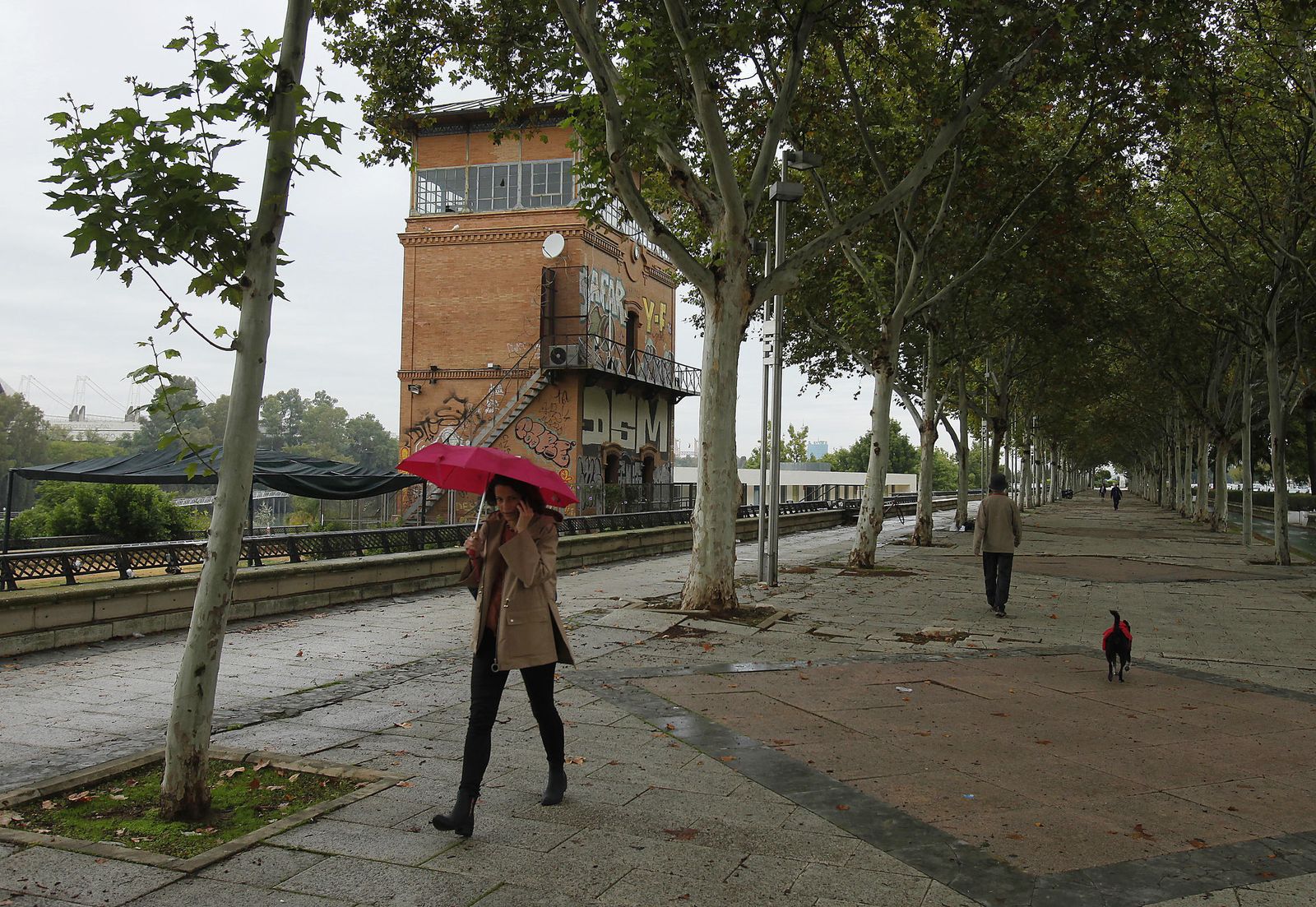 Una chica pasea junto a la torre de Renfe de la calle Torneo.
