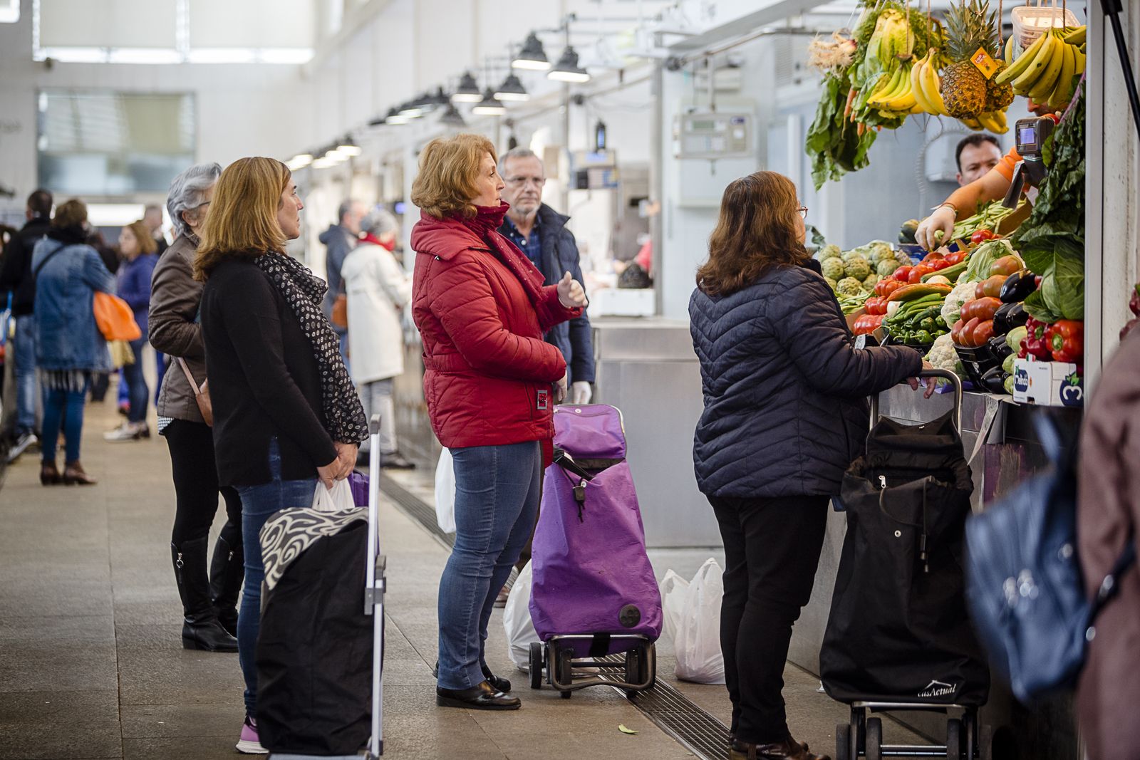 Clientes esperan su turno en una frutería del mercado central