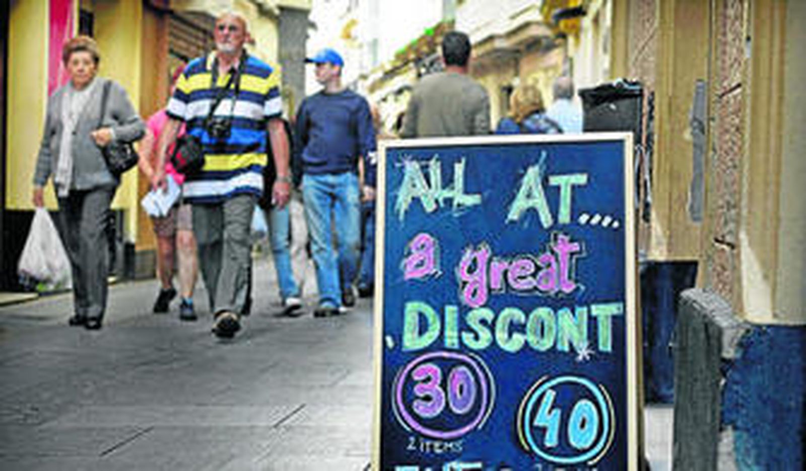 Un comercio  muestra un cartel anunciando en inglés varios descuentos.