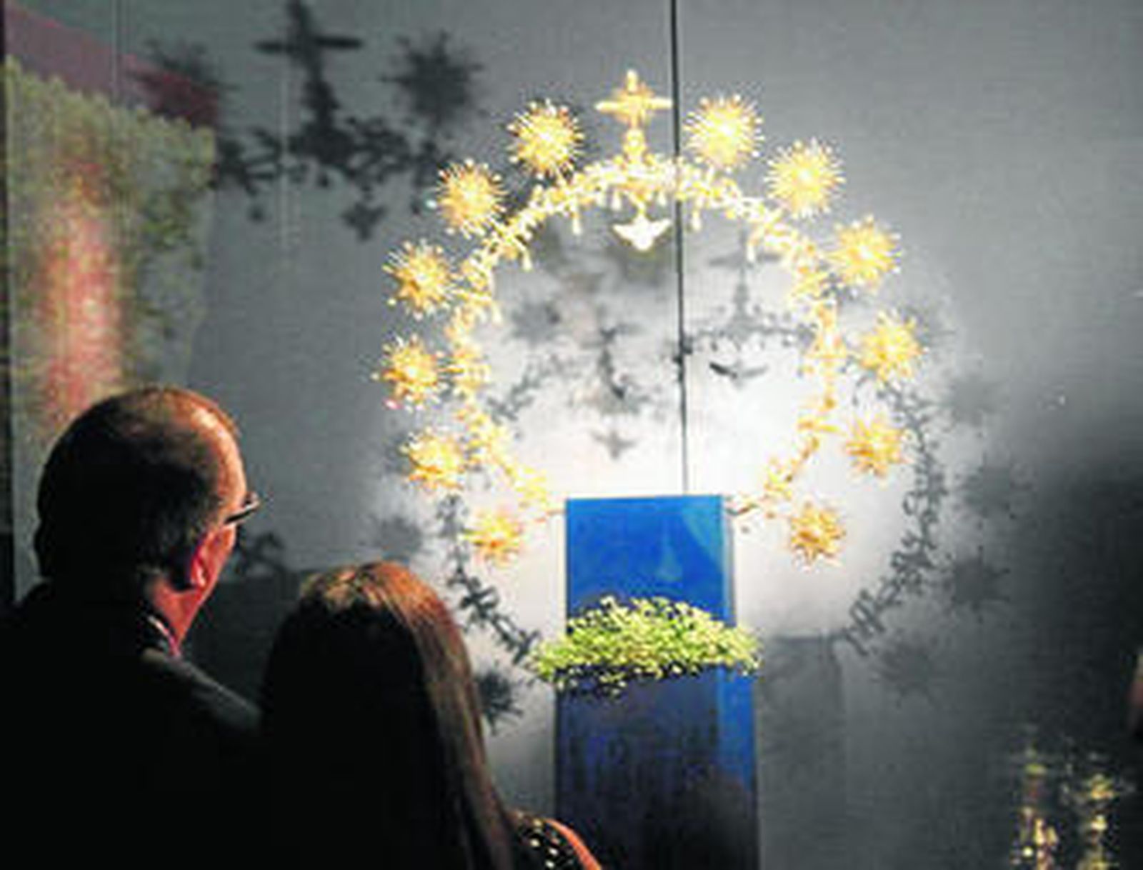 Dos asistentes a la exposición contemplan el halo de Coronación.