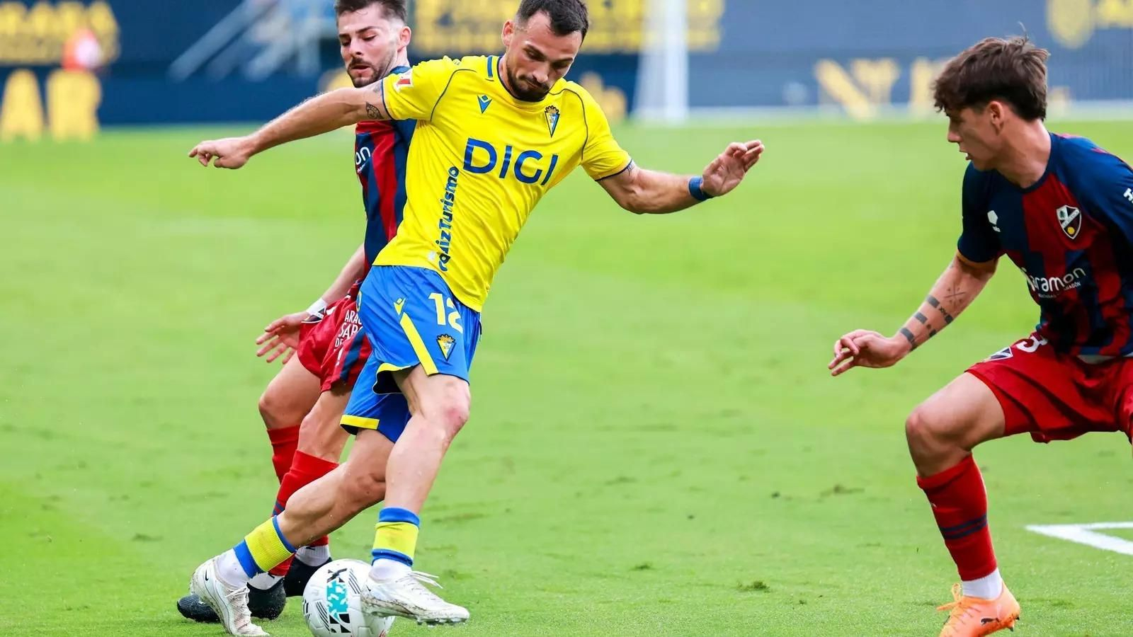Iuri Tabatadze, en un partido con el Cádiz CF, tratando de superar a rivales del Huesca