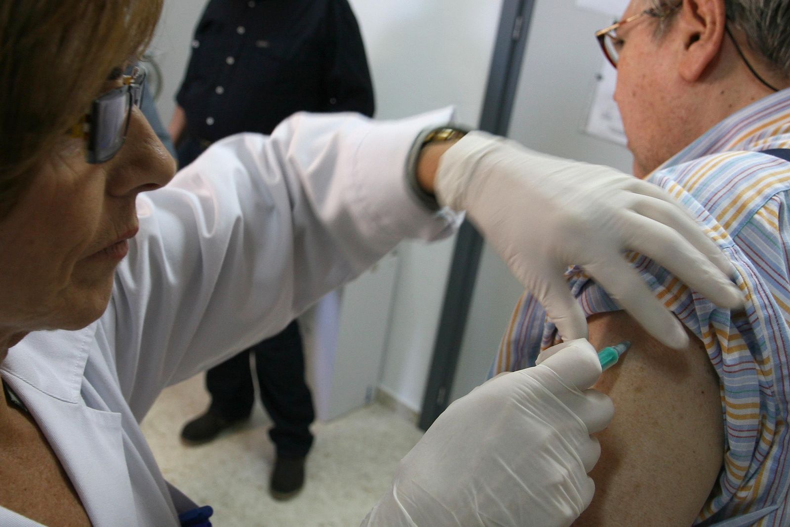 Una enfermera vacuna contra la gripe a un hombre.