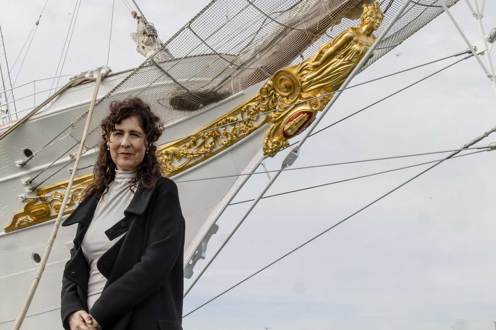Paz Barbero, junto al mascarón de proa de Elcano, restaurado por ella.