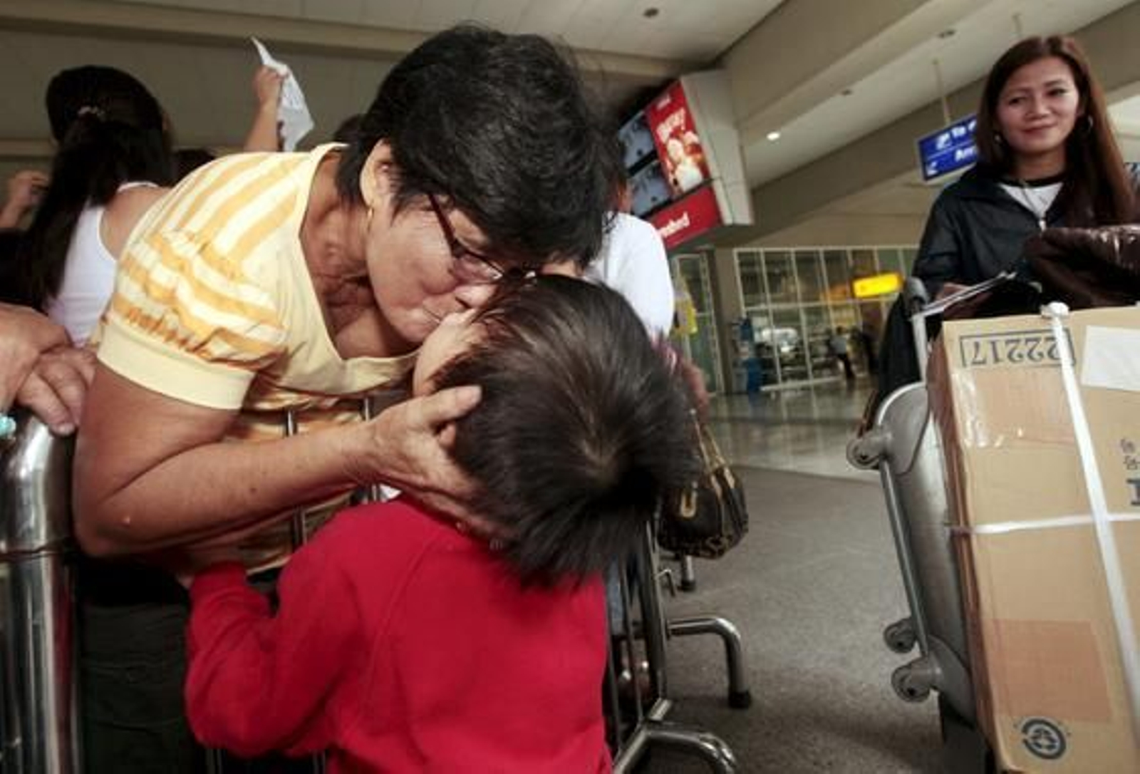 Una mujer filipina saluda a sus familiares a su llegada de Japón.