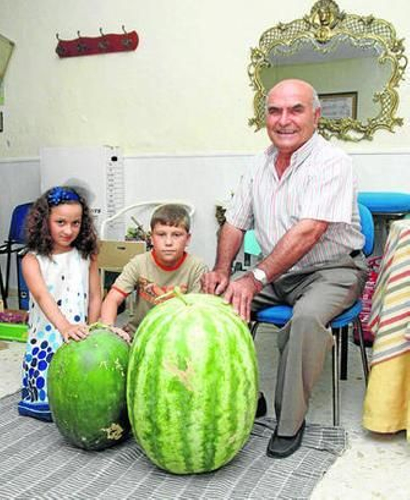 El Platero muestra las sandías ganadoras junto a sus nietos.