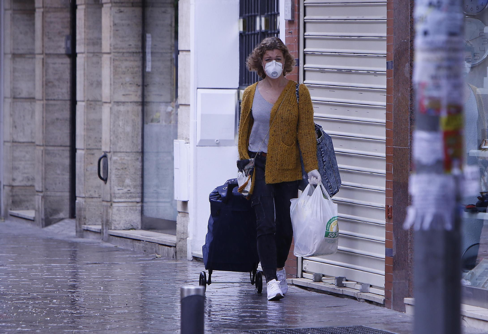 Una mujer regresa a su casa tras hacer la compra.