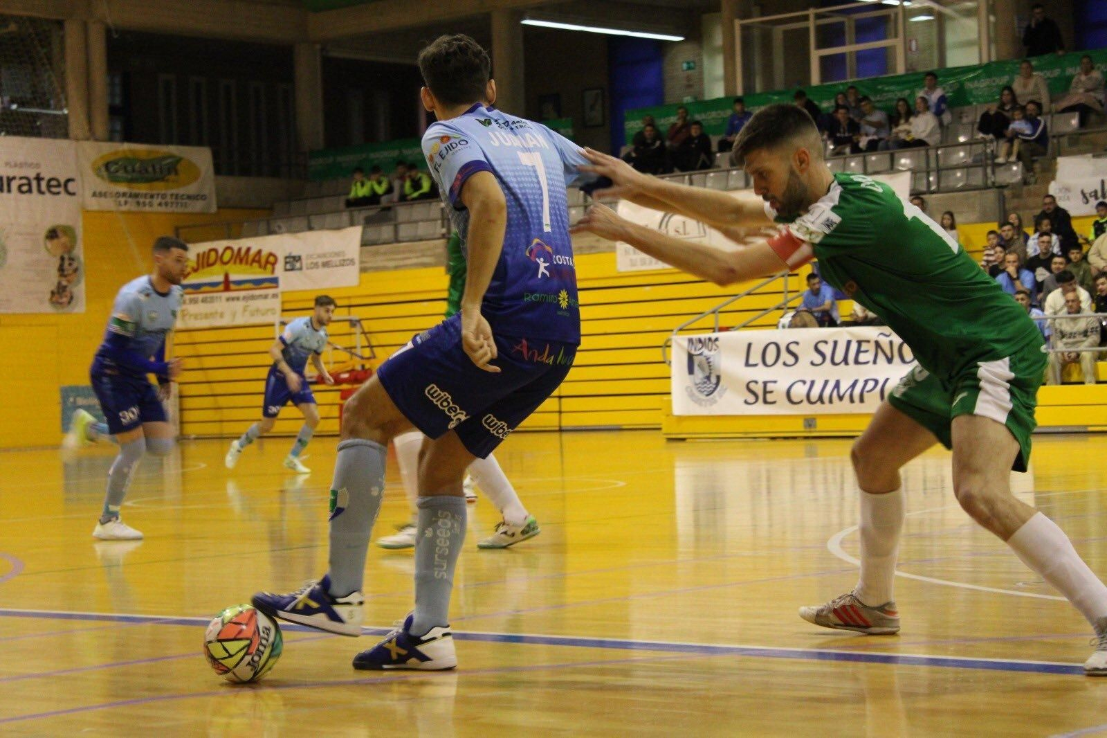 El celeste Juanan protege de espaldas el balón ante la presión de un rival en un partido.
