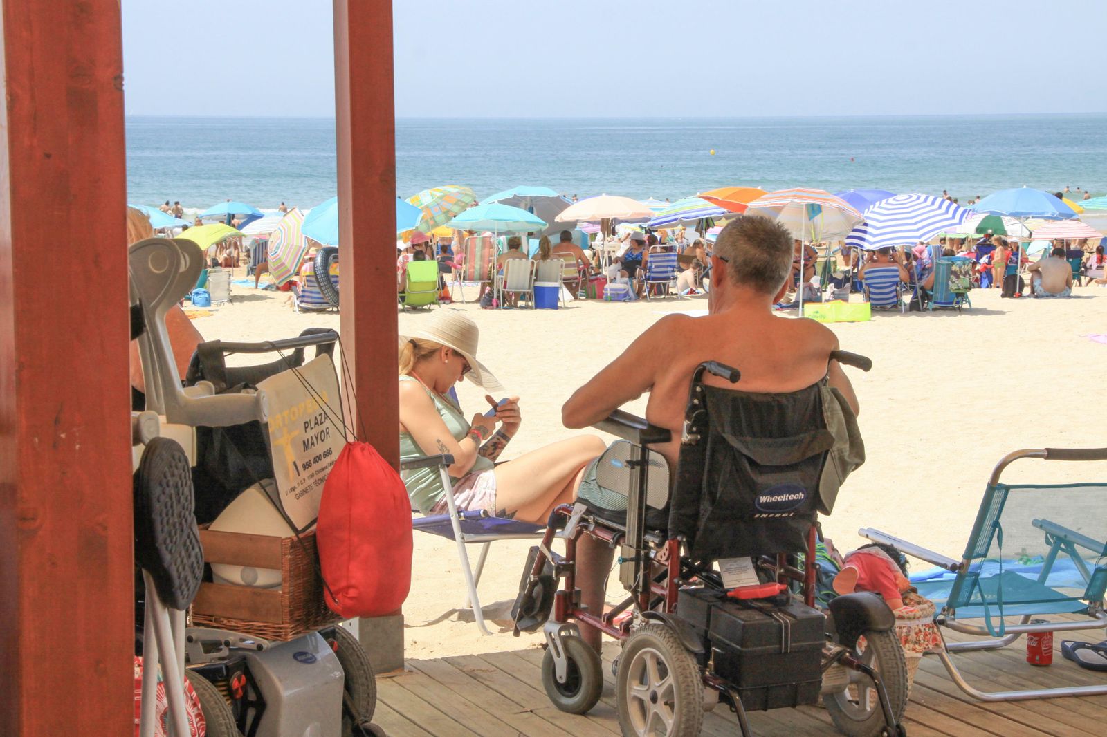 Un hombre en sillas de ruedas en el módulo de la Cruz Roja en La Barrosa.