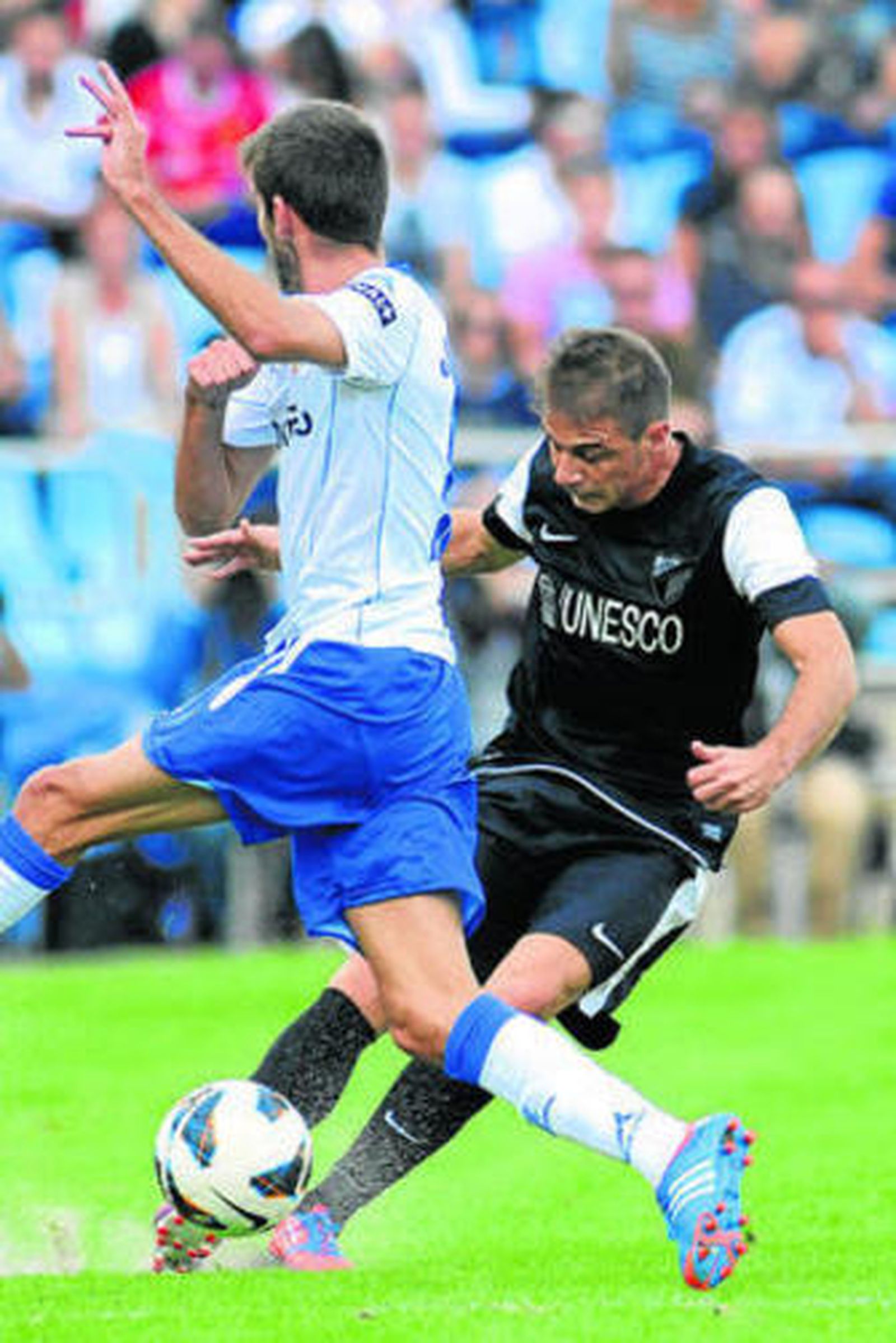 Joaquín centra el balón ante un defensor zaragocista.