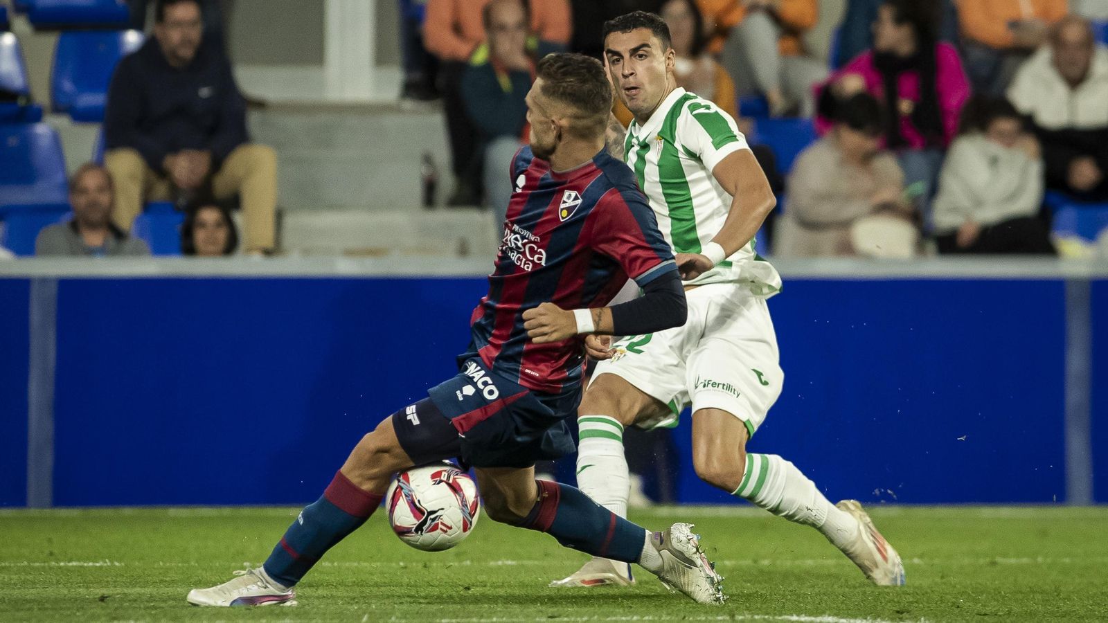 Carlos Isaac intenta sacar un centro en el Huesca - Córdoba CF.
