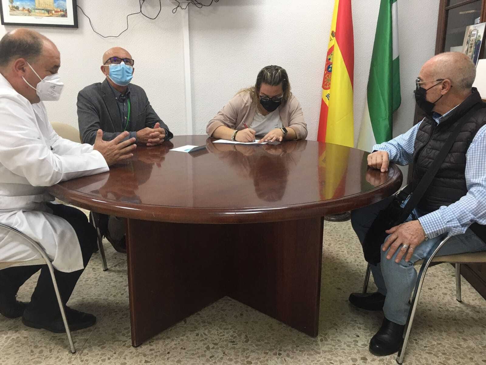 Representantes de El Rocío de Cádiz firman la donación de los televisores ante el gerente del hospital Puerta del Mar, Sebastián Quintero.