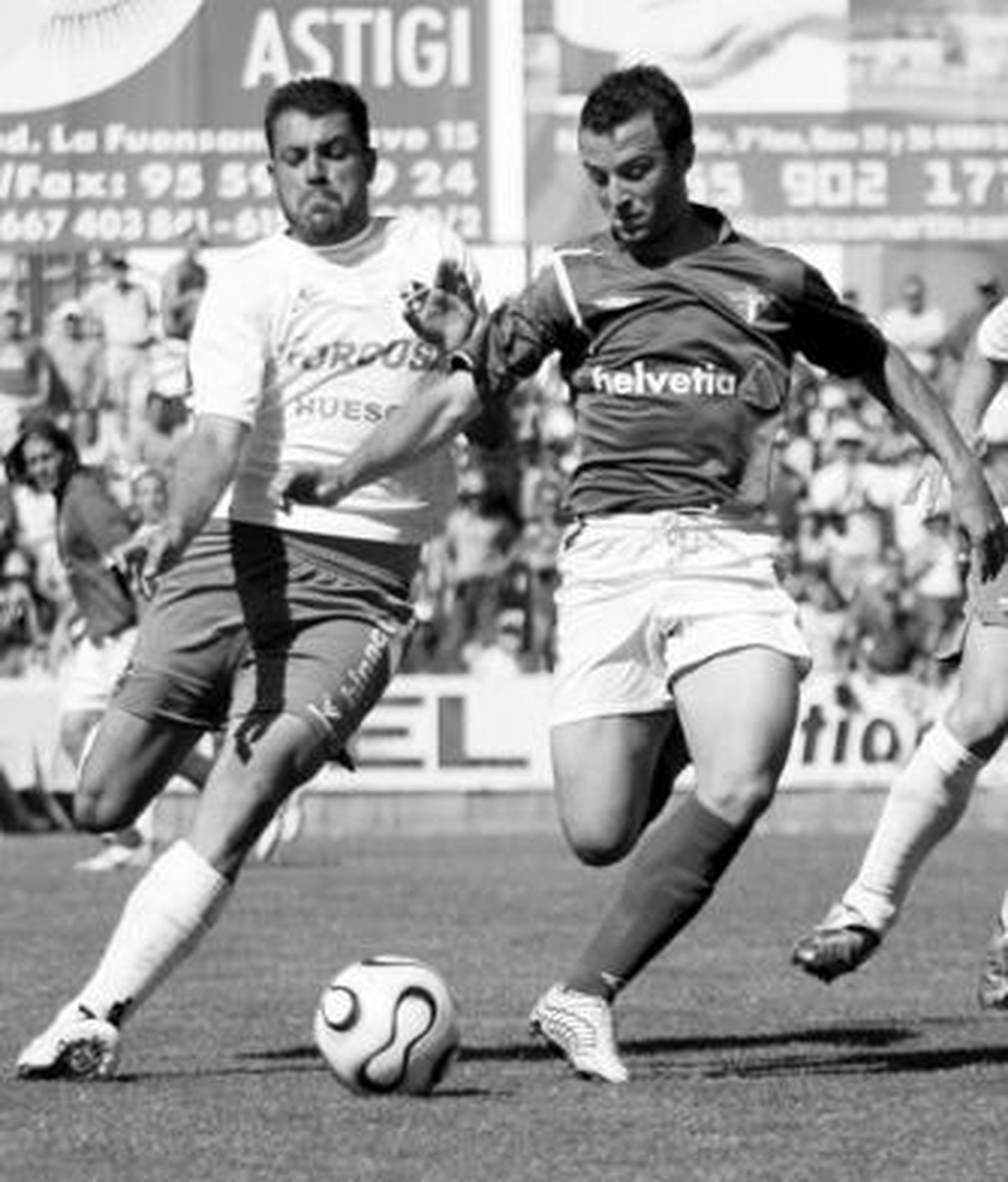 Pepe Díaz lucha con un jugador del Huesca en el último 'play off'.