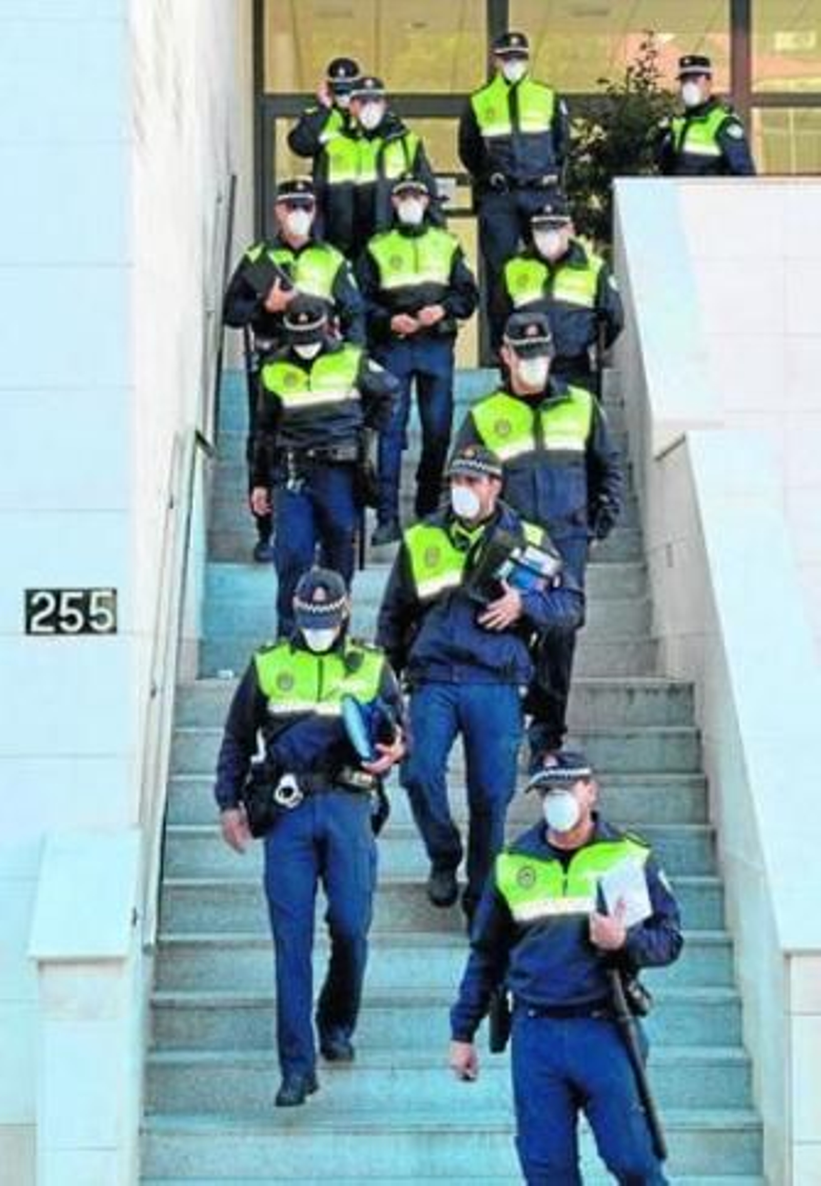 Policías salen de la Jefatura policial con mascarillas puestas.