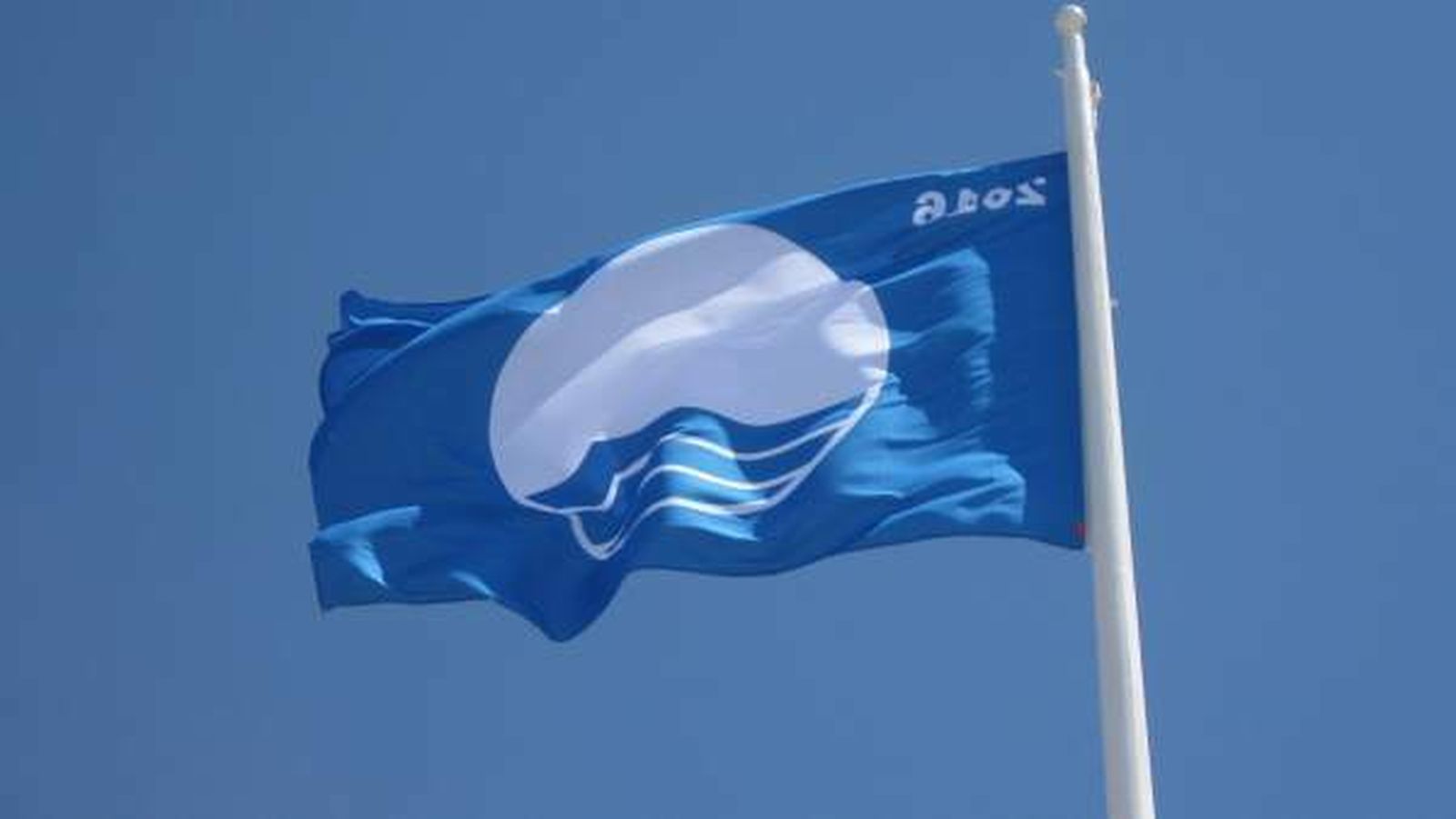 Una bandera azul, ondeando en una playa