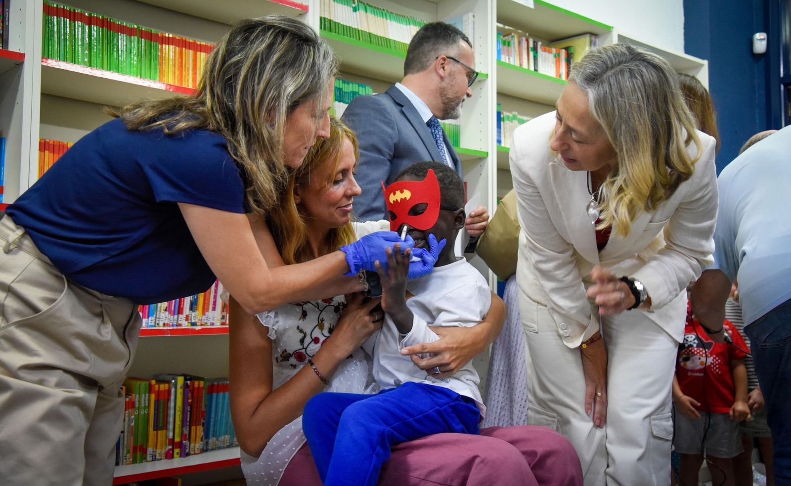 Un menor recibe la vacuna intranasal de la gripe en un colegio de Sevilla durante la visita de la consejera de Salud y Consumo, Rocío Hernández.