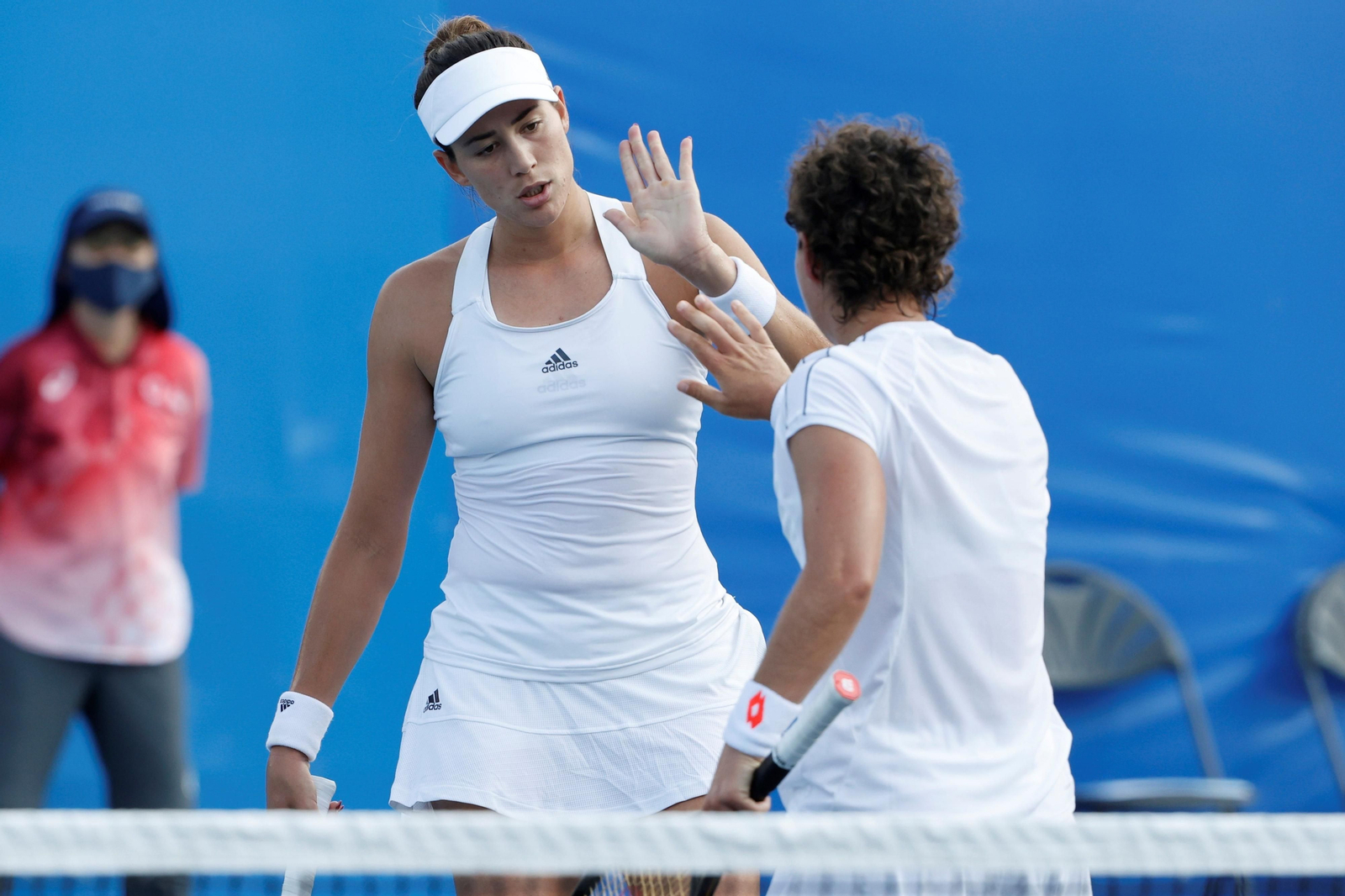 Carla Suárez, de espaldas, y Garbiñe Muguruza se felicitan tras un punto.