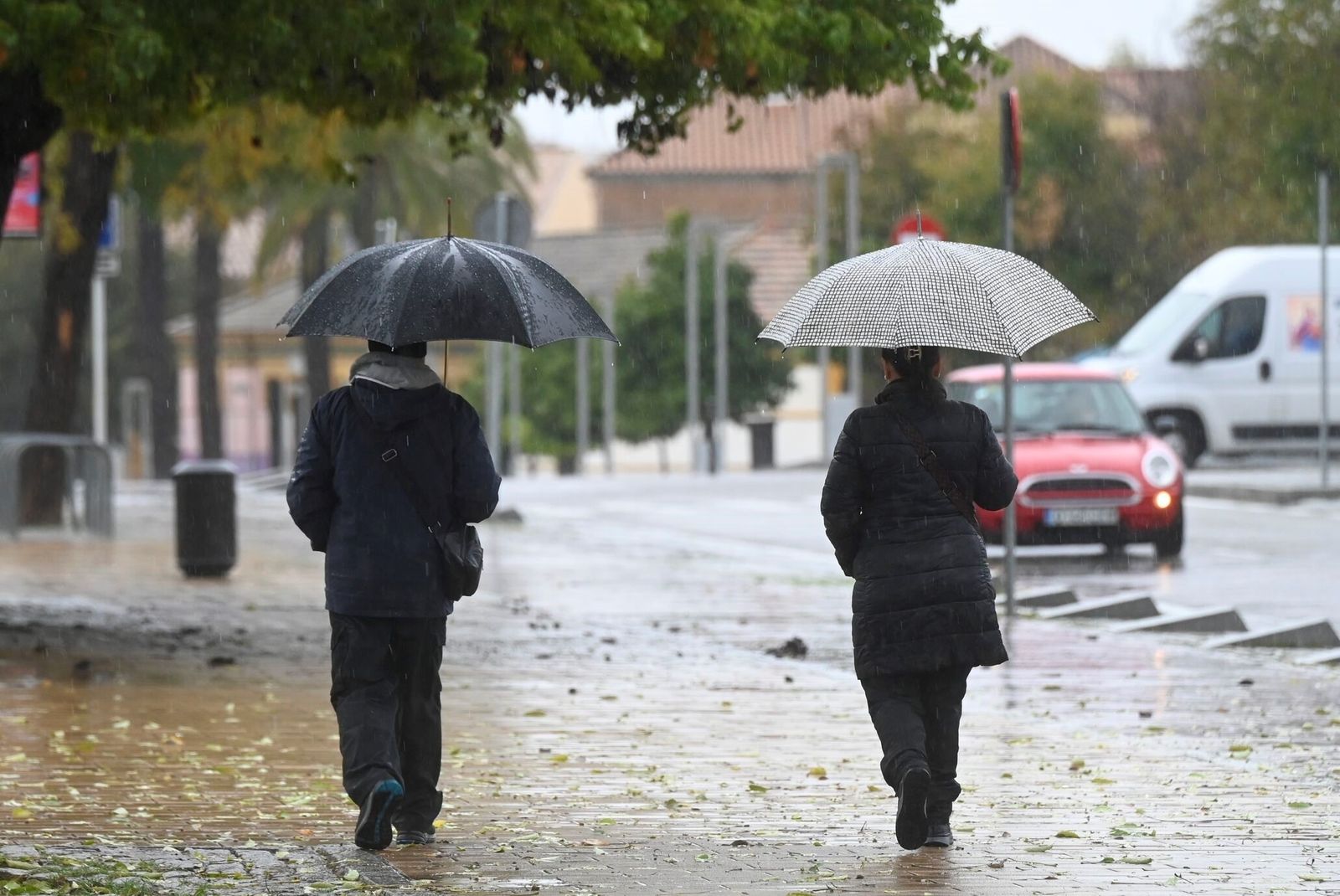 Dos personas caminan bajo la lluvia en Córdoba.