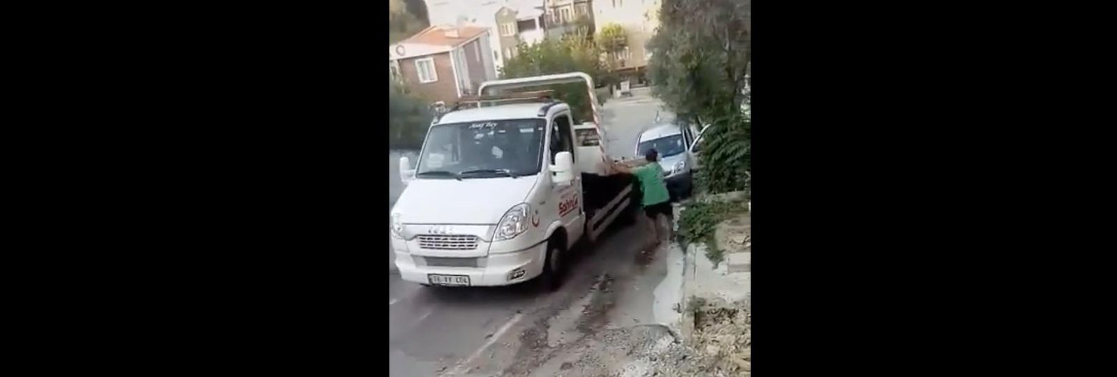 Un operario de grúa intenta evitar que su vehículo choque con el coche accidentado