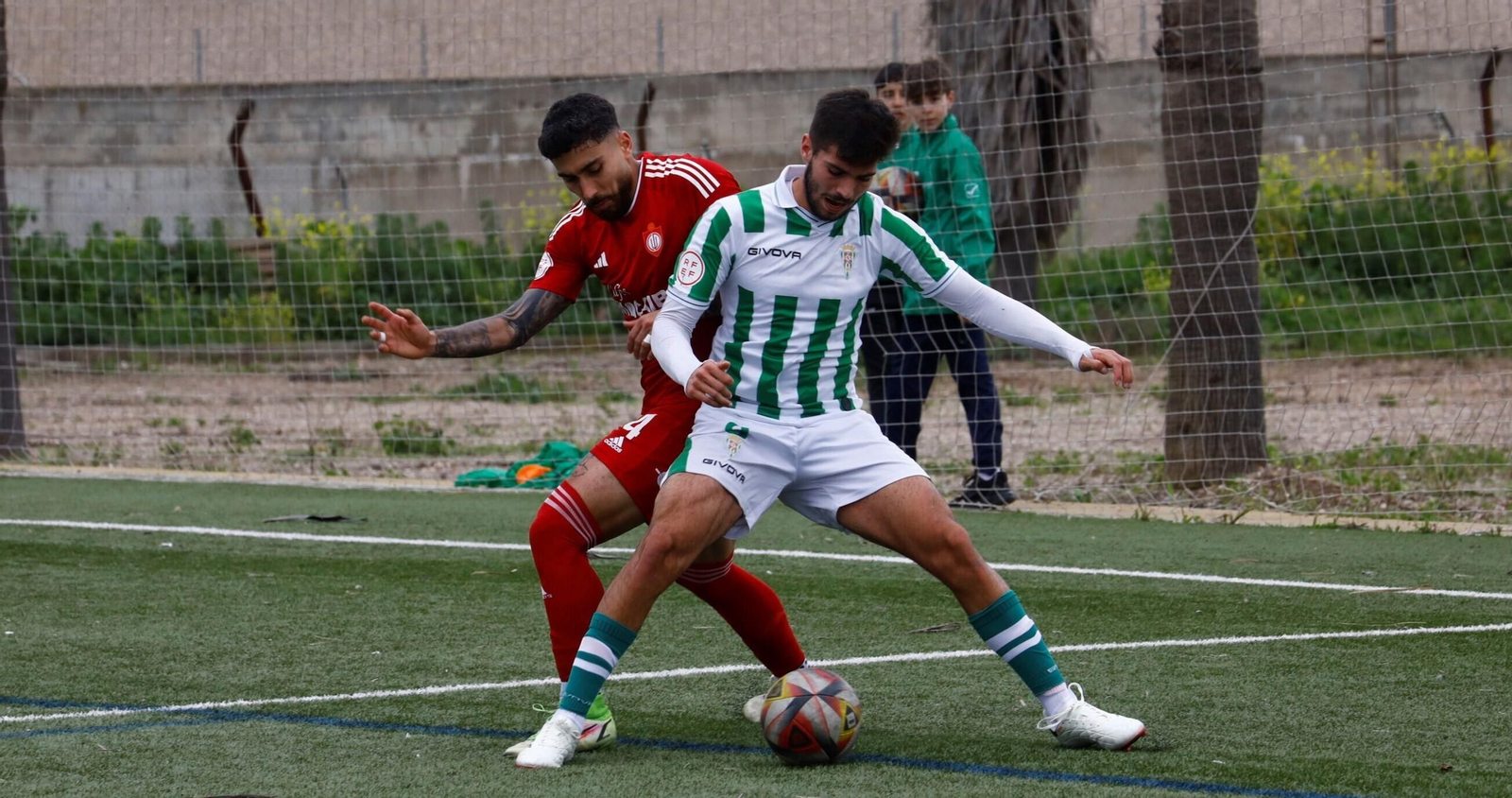 Óscar Jiménez, delantero del Córdoba B, pelea por el balón con un jugador del Utrera.