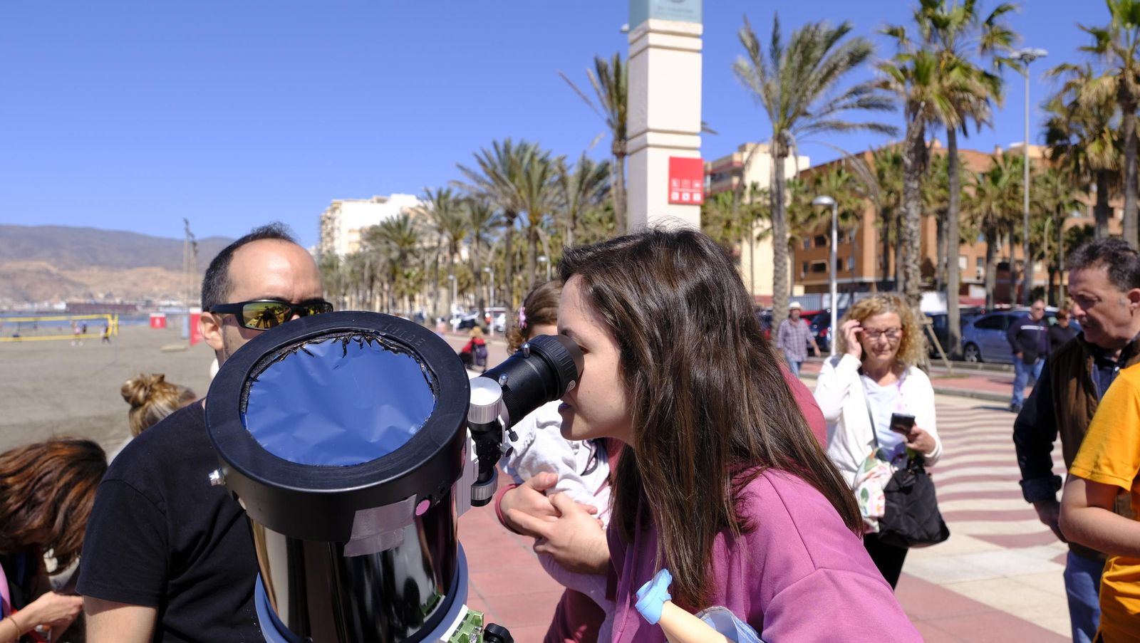 Almería observa el eclipse solar desde el Paseo Marítimo, en imágenes