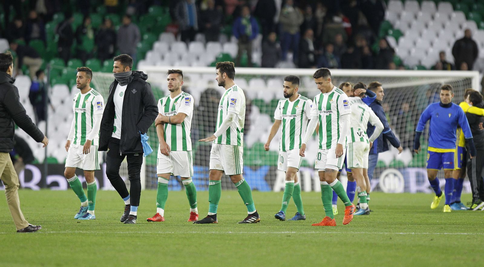 Los jugadores béticos abandonan el césped cabizbajos al terminar el encuentro.