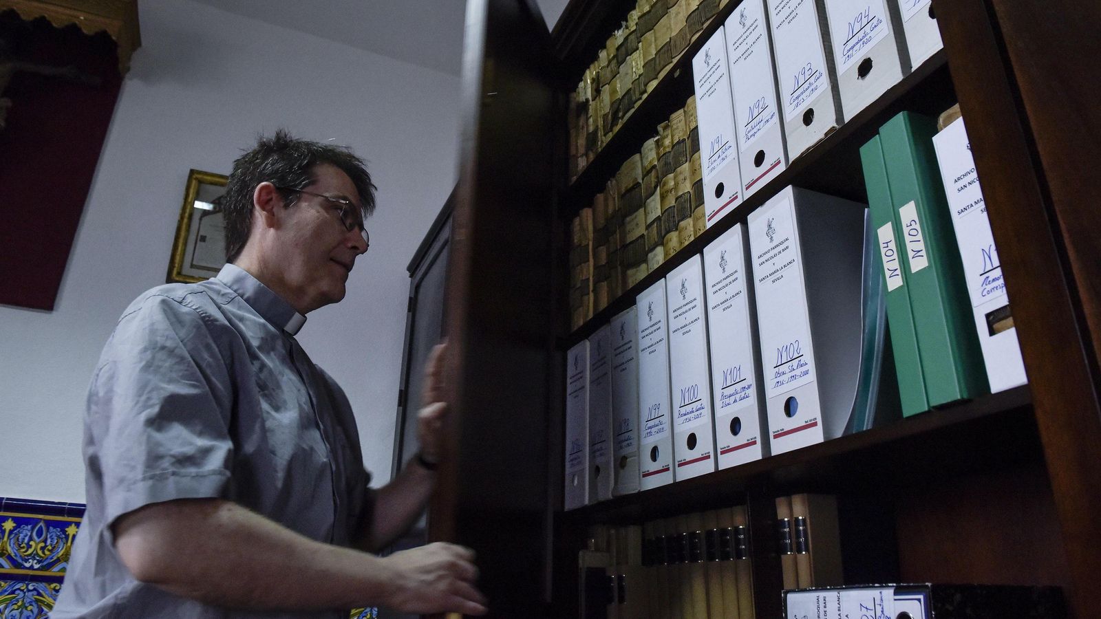El párroco Miguel Ángel Núñez, abre uno de los armarios del archivo.