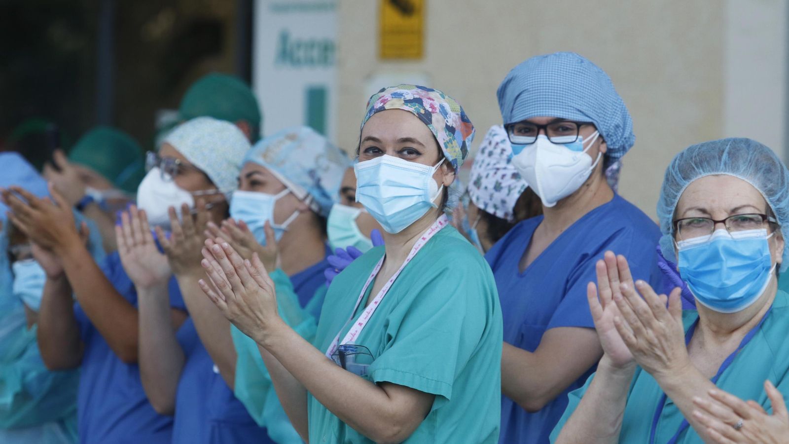 Varios sanitarios aplauden a las puertas de su centro hospitalario.