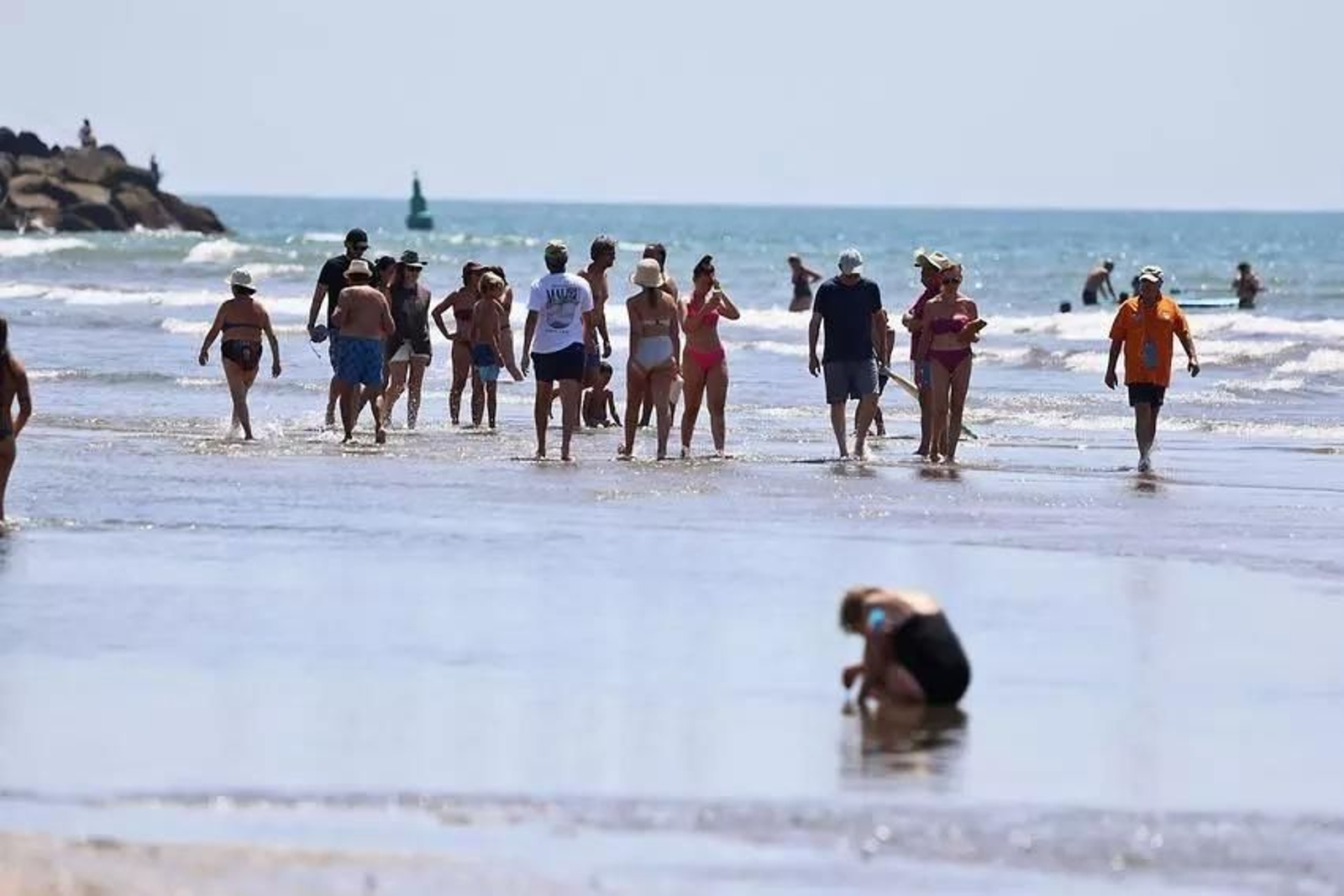 Gente paseando por la orilla de una de las playas de Huelva.
