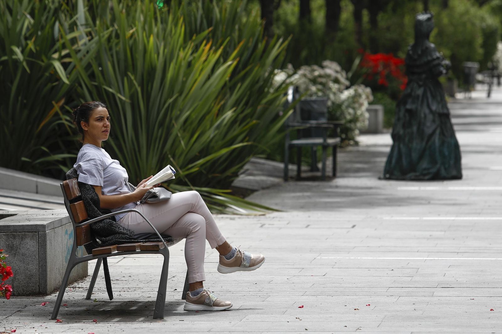 Una mujer lee un libro ayer en el bulevar de la Avenida de la Constitución
