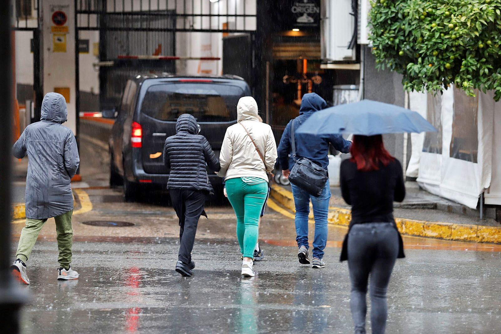 Ciudadanos con paraguas y chubasqueros.
