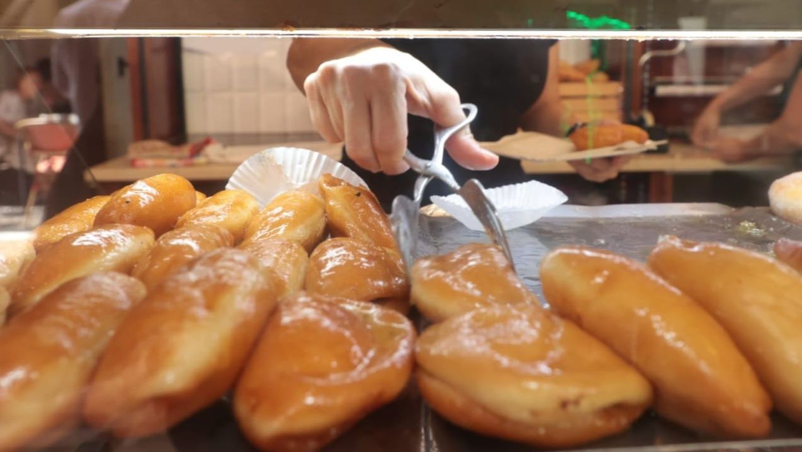 La dependienta prepara una bandeja de japonesas en la confitería La Modelo.