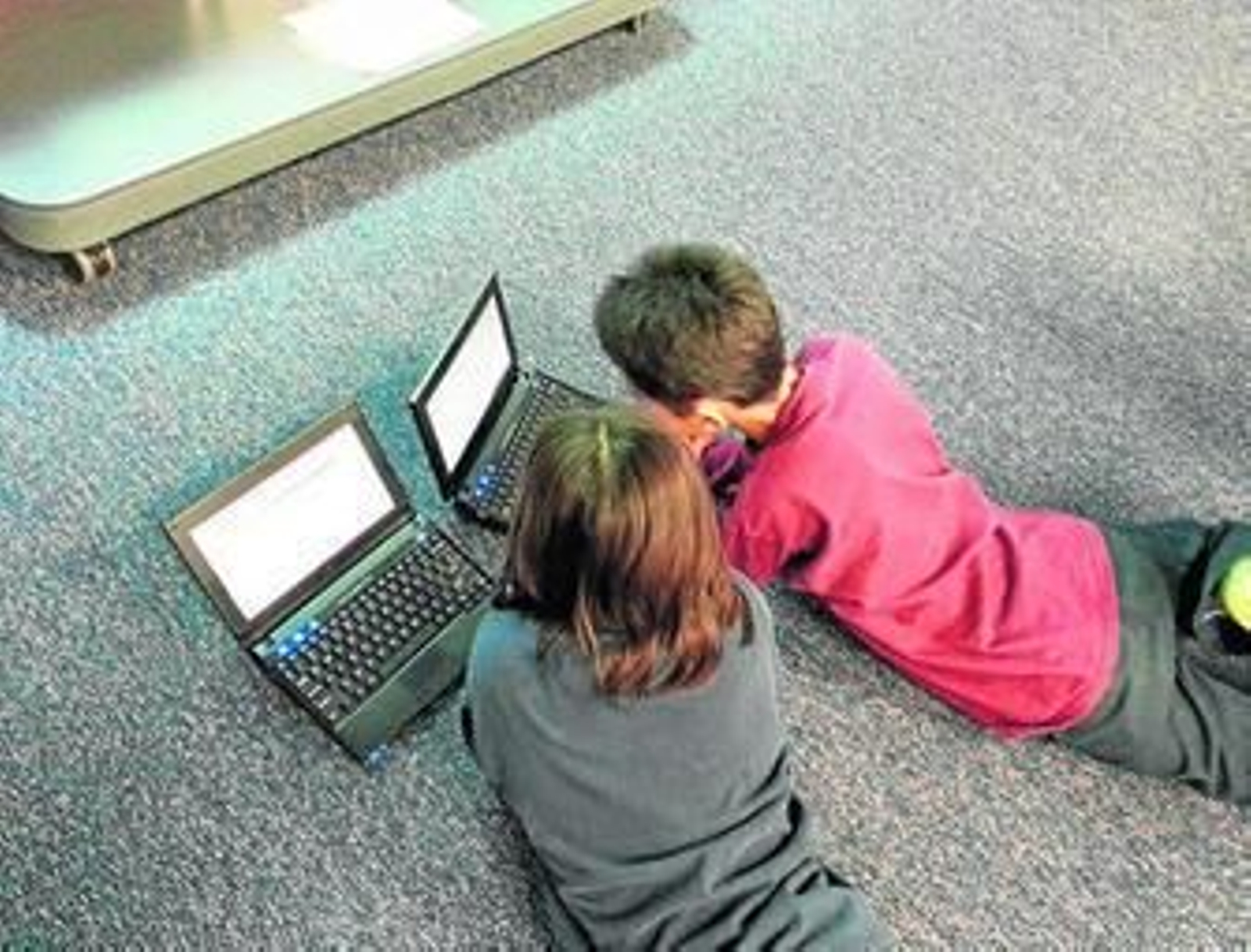 Dos jóvenes juegan con ordenadores.